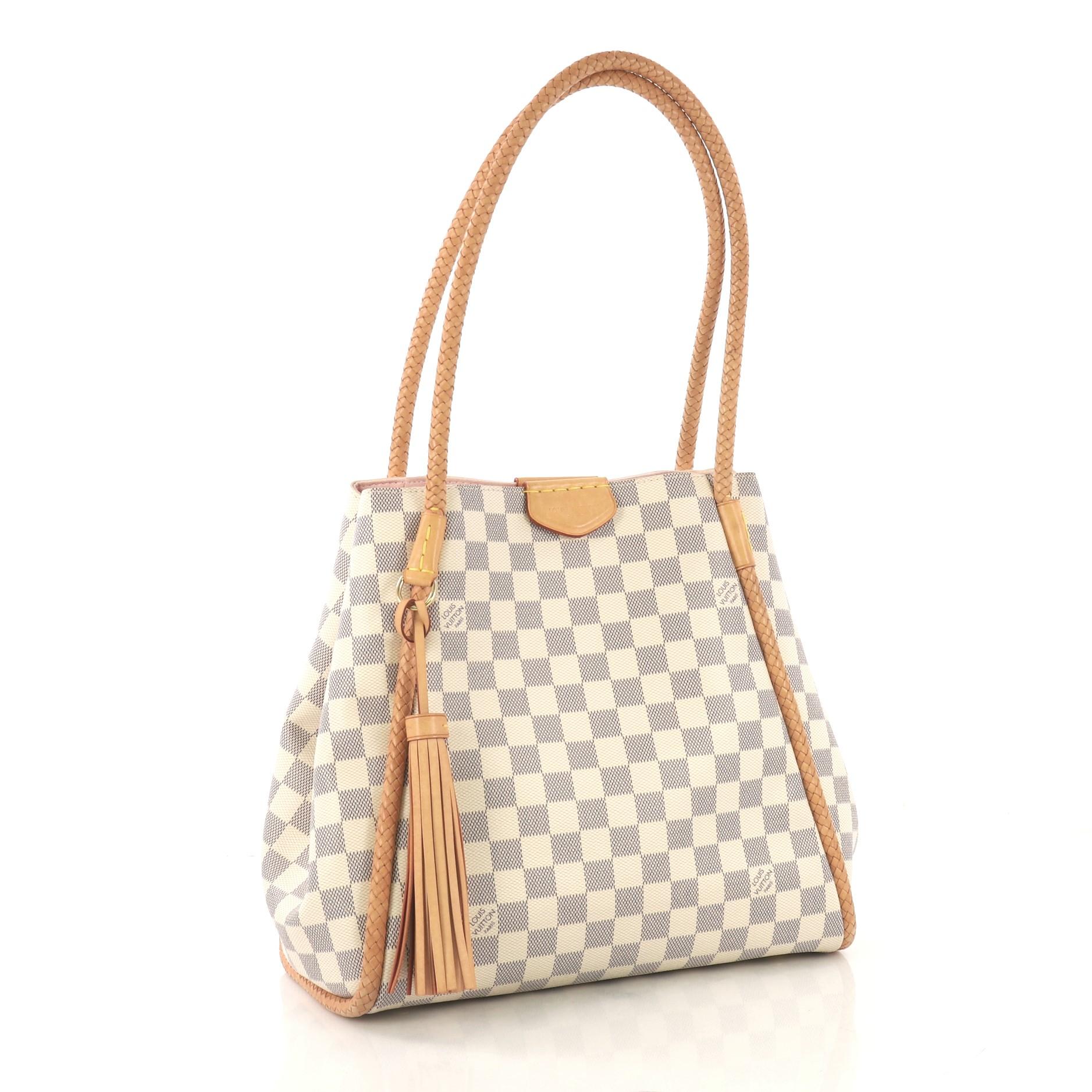 This Louis Vuitton Propriano Handbag Damier, crafted in damier azur coated canvas, features braided leather piping and handles, fringe tassel, and gold-tone hardware. Its magnetic closure opens to a light pink microfiber interior with zip pocket.