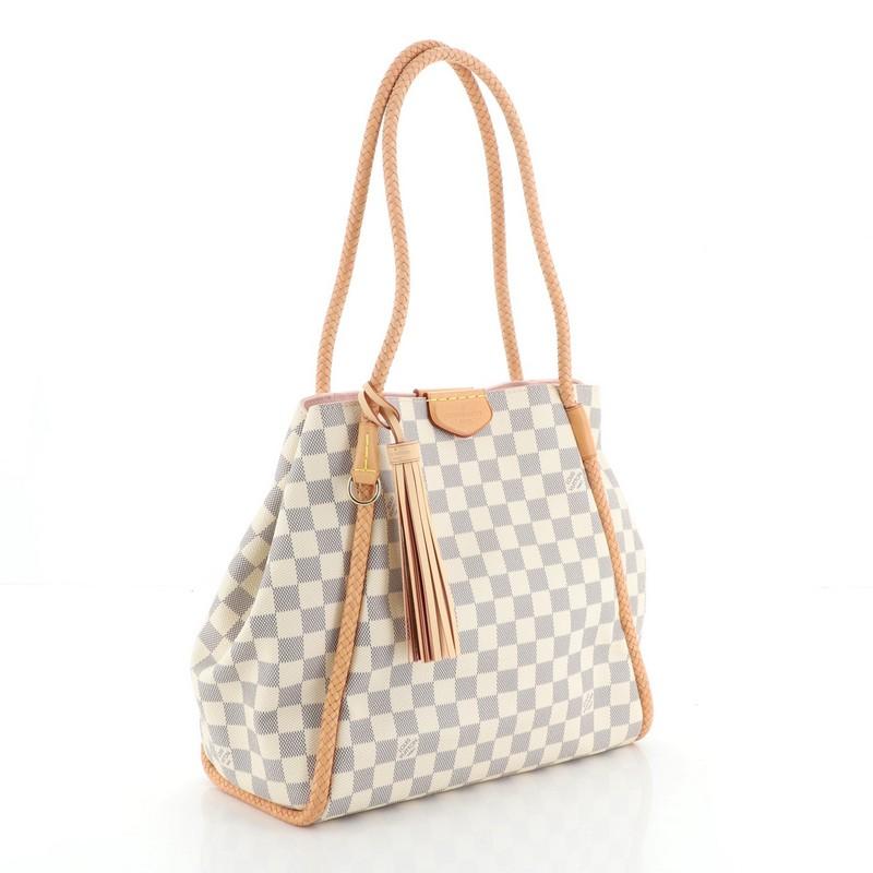This Louis Vuitton Propriano Handbag Damier, crafted from damier azur coated canvas, features braided vachetta leather shoulder straps, tassel charm, and gold-tone hardware. Its magnetic snap closure opens to a pink microfiber interior with zip