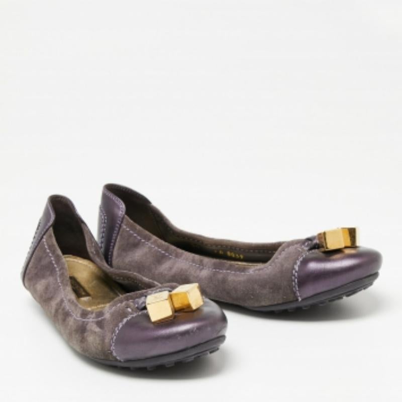 These lovely ballet flats by Louis Vuitton are high on elegance and comfort. Made from suede and leather with gold-tone dice detailing on the vamps, they feature rounded toes and a scrunch style. The purple flats have durable pebbled soles and