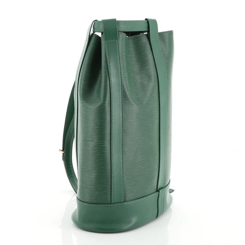This Louis Vuitton Randonnee Backpack Epi Leather PM, crafted from green epi leather, features adjustable leather cinch strap, subtle LV logo, and gold-tone hardware. Its cinch strap closure opens to a green microfiber interior. Authenticity code