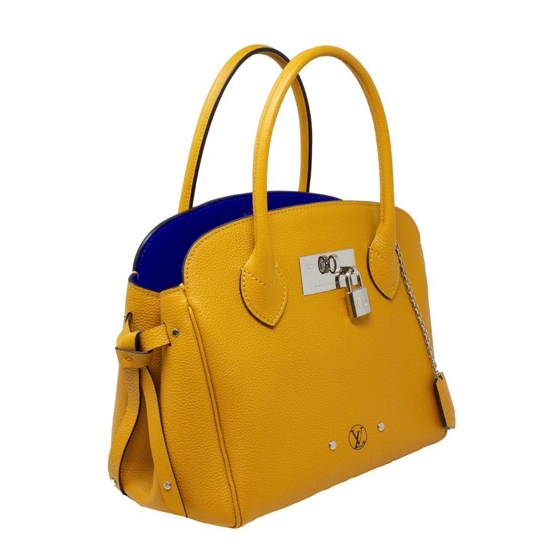From Rodeo Drive, in beautiful Orange Veau Nuage, this Louis Vuitton Milla PM features gold hardware and an open top that leads to a gorgeous LV blue leather-lined interior with one zippered and one slip pocket, designed for day-to-night