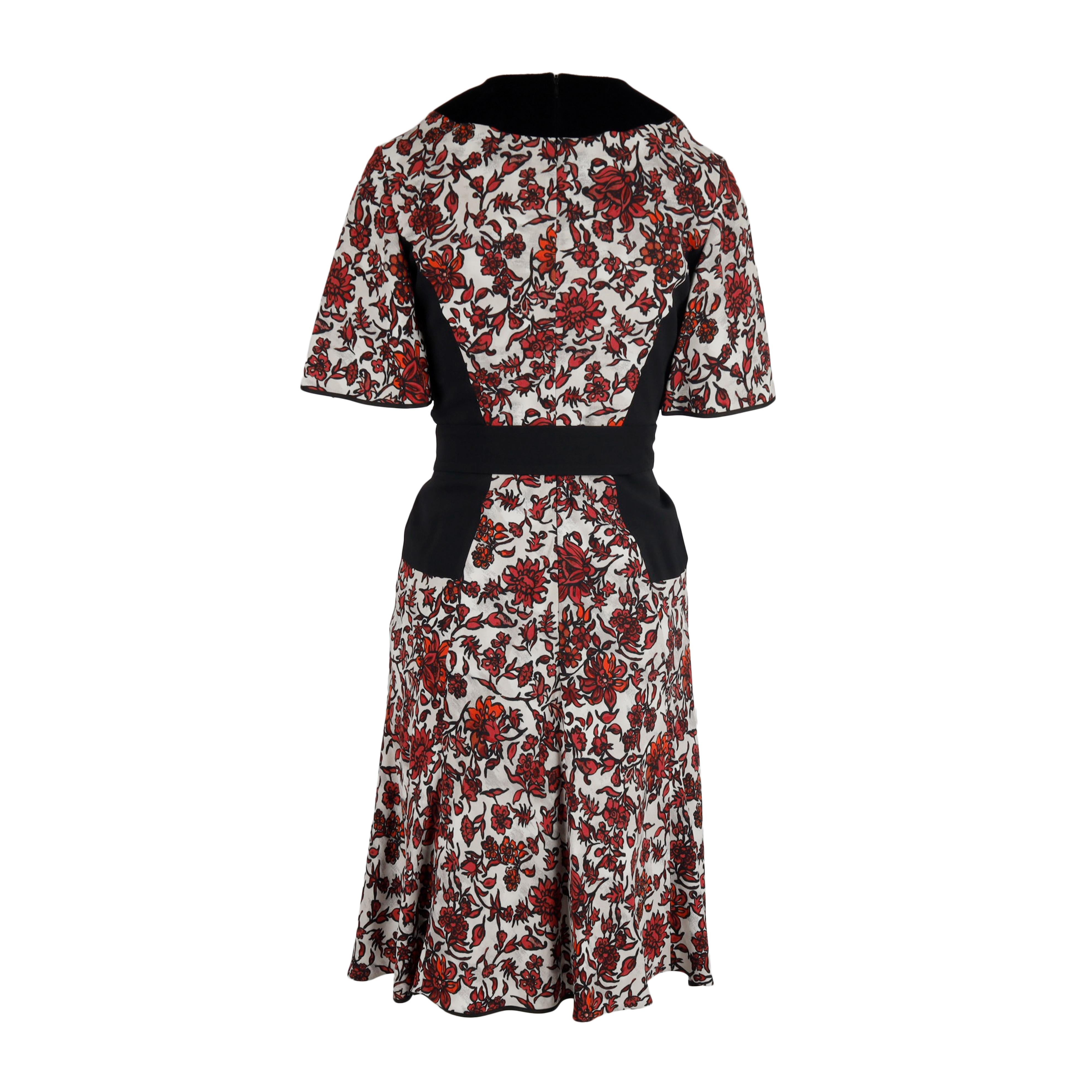 Featuring a bold floral motif in red, black and white, this fit and flare dress makes a statement with a velvet collar, corset-like waist detail, and self-tie bow belt. Further complemented with fluted angel half sleeves and a concealed back zip,