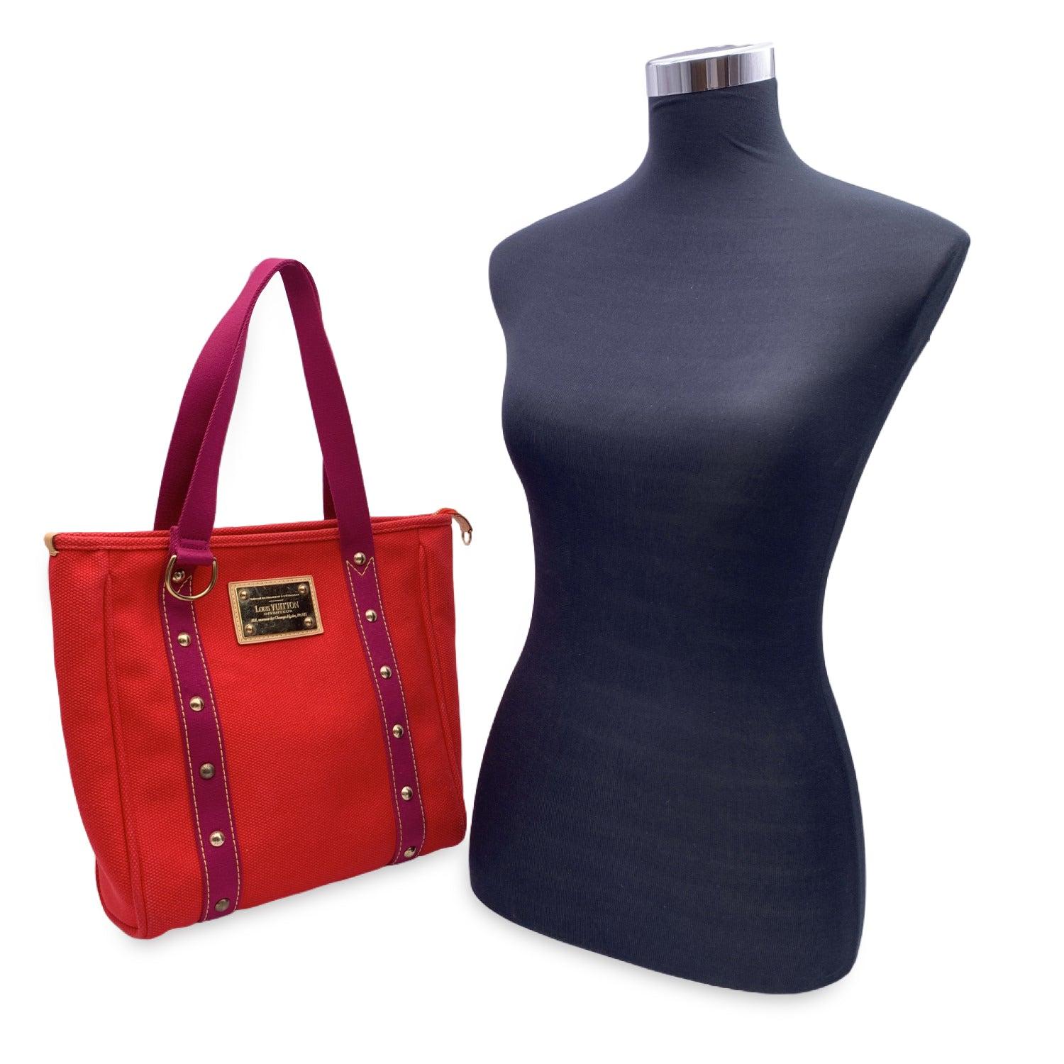 Elegant Louis Vuitton ANTIGUA Tote. The bag is crafted of red canvas with magenta trim and handles. The line it is inspired by a nautical style infact the collection is named after the Caribbean island, known for its yacht races. This model features