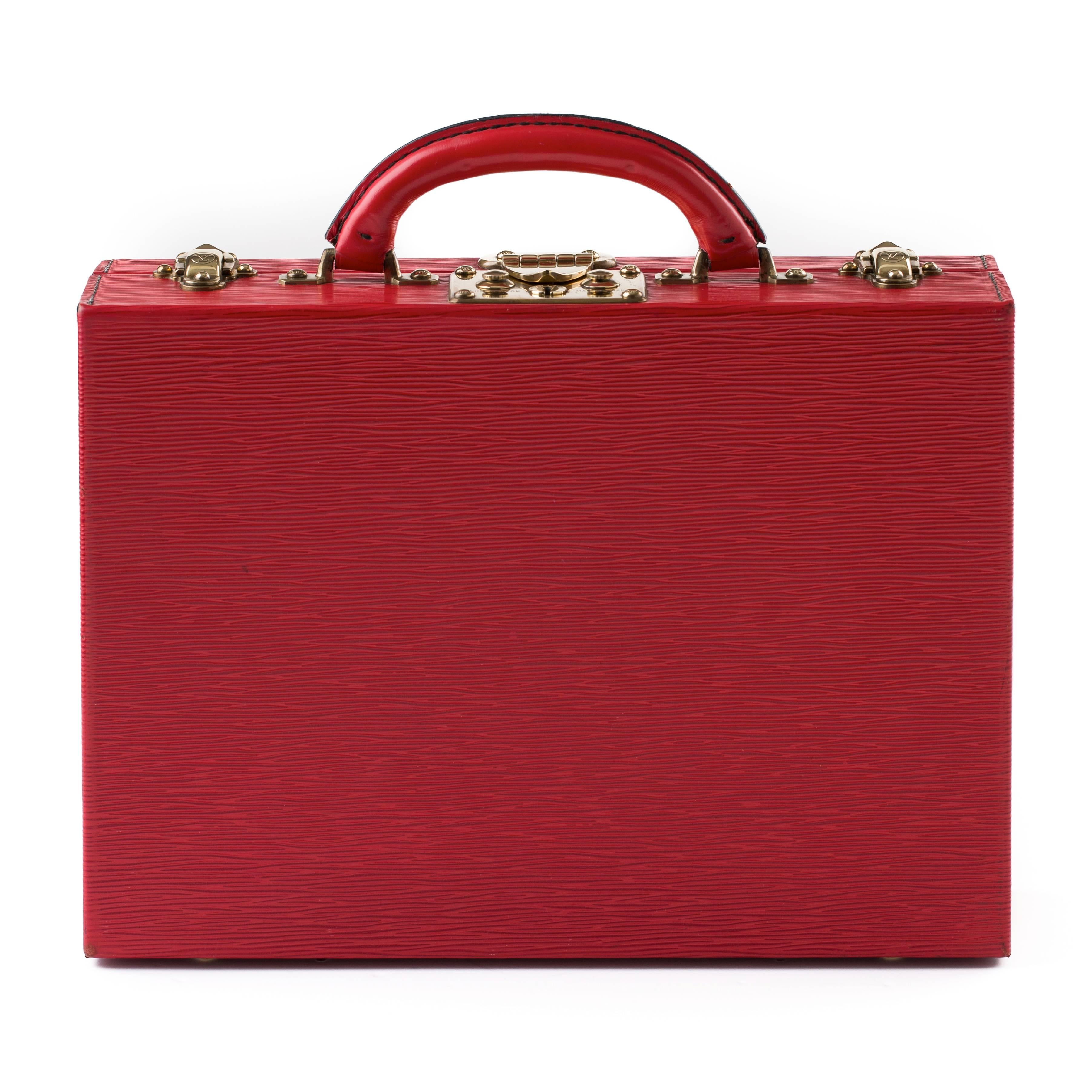 Beautiful Louis Vuitton jewelry case in red Epi leather with brass hardware.
The jewellery case features a black leather lined interior with one removable tray.
The compartments in the removable tray and in the underside of the case are all lined
