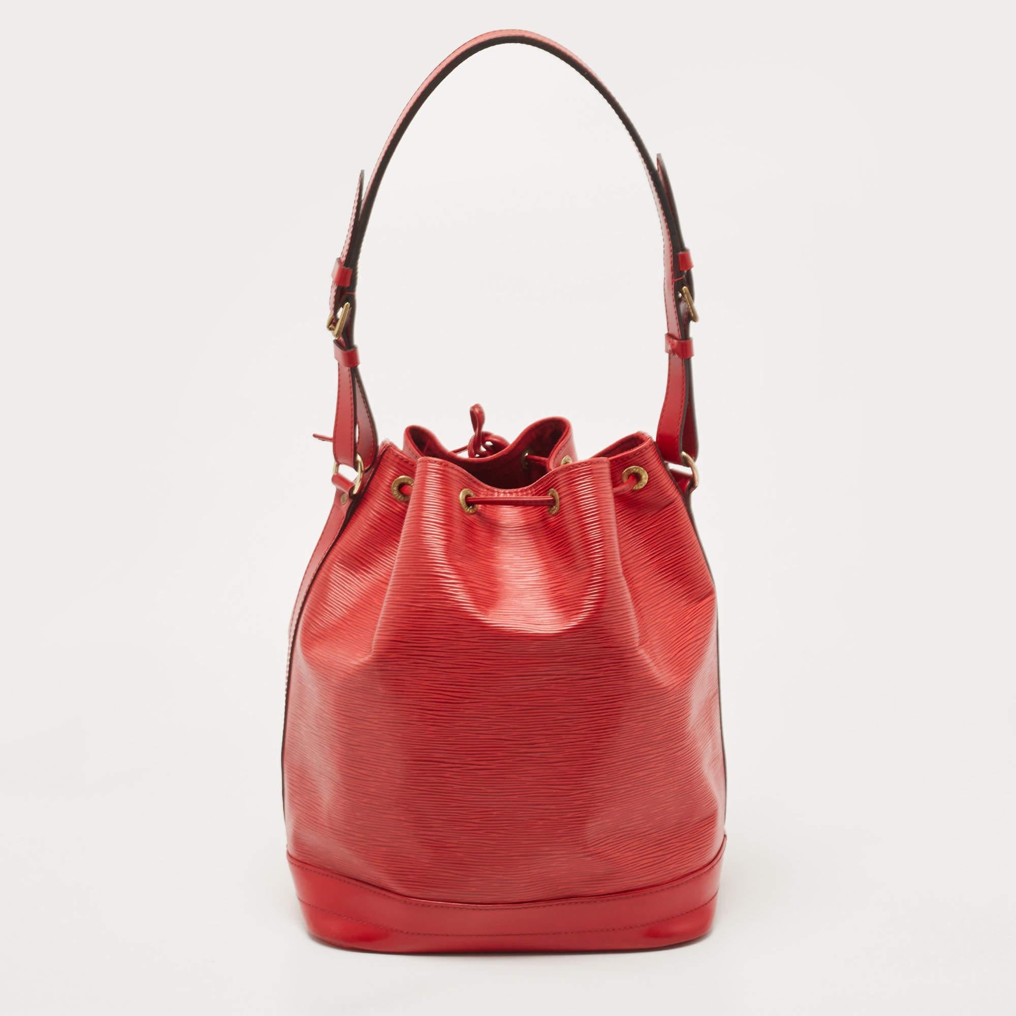 Created in 1932 by Louis Vuitton to carry bottles of Champagne, the iconic Noe now serves as a stylish daytime handbag. Crafted from red Epi leather, the bag exudes just the right amount of sophistication. It has a single adjustable strap, gold-tone
