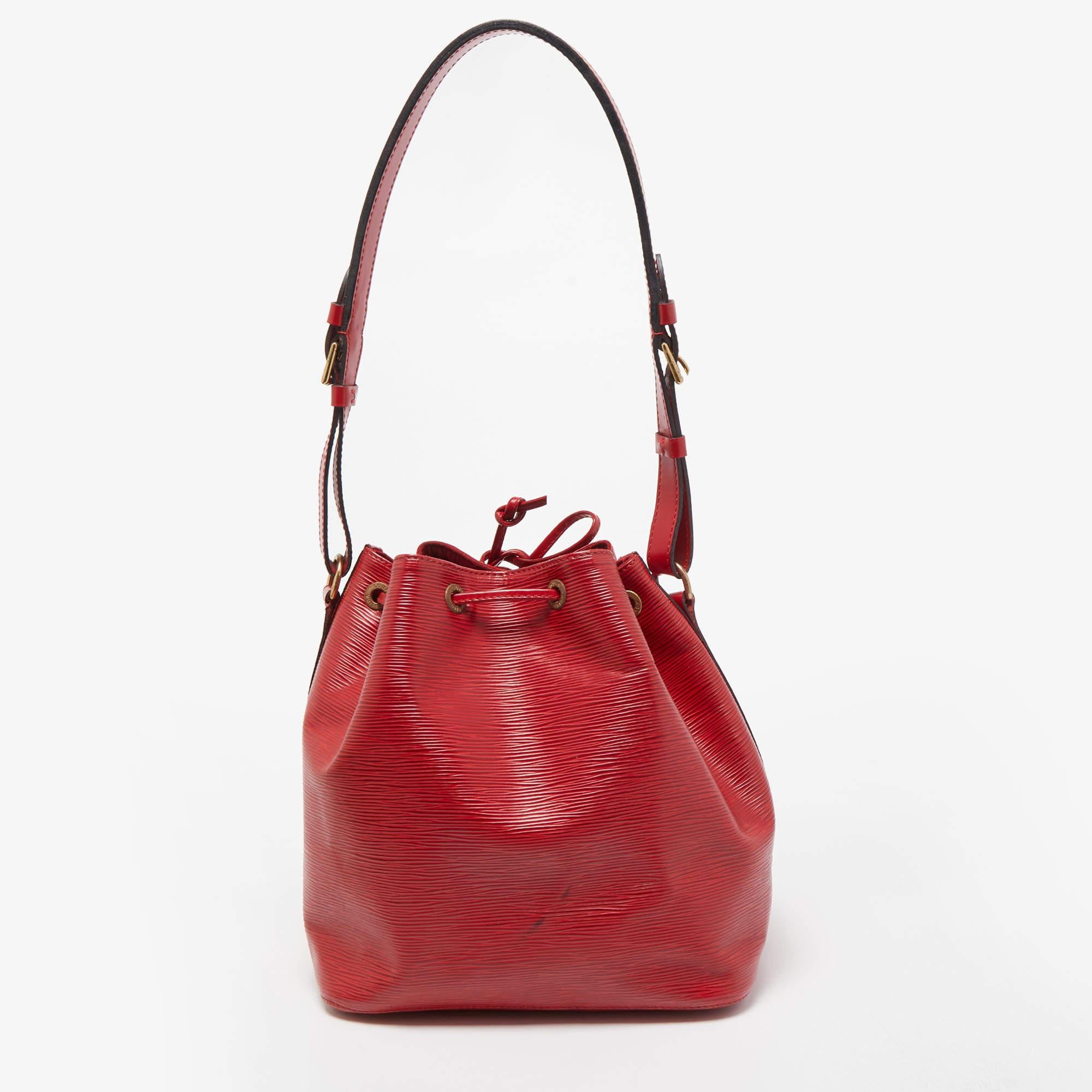 Created in 1932 by Louis Vuitton to carry bottles of Champagne, the iconic Noe now serves as a stylish daytime handbag. Crafted from red Epi leather, the bag exudes just the right amount of sophistication. It has a single adjustable strap, gold-tone
