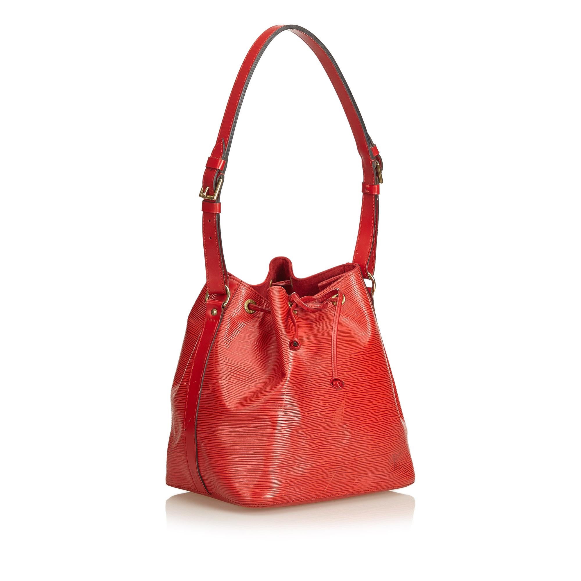 The Louis Vuitton Noe is a sweet bucket bag featuring a rich red epi leather body, adjustable flat strap, open top with a drawstring closure, and Alcantara lining.

Strap drop: 28cm.
Serial number: AR1905