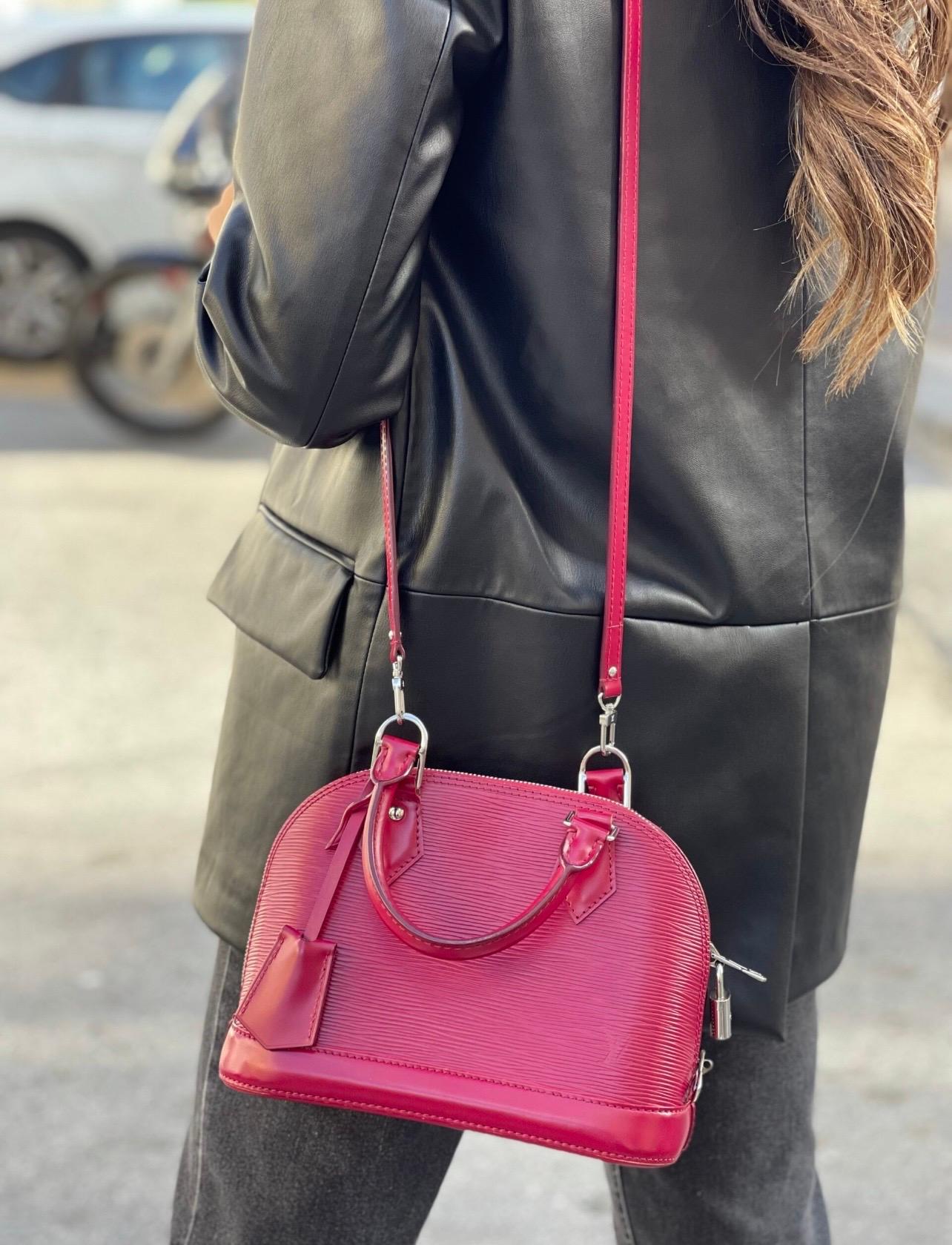 Louis Vuitton Alma BB handbag in Epi leather with silver hardware.  It also features a removable leather shoulder strap.  Central opening with zip and padlock closure with keys.  Interior in burgundy suede with a side pocket.  Condition of the bag