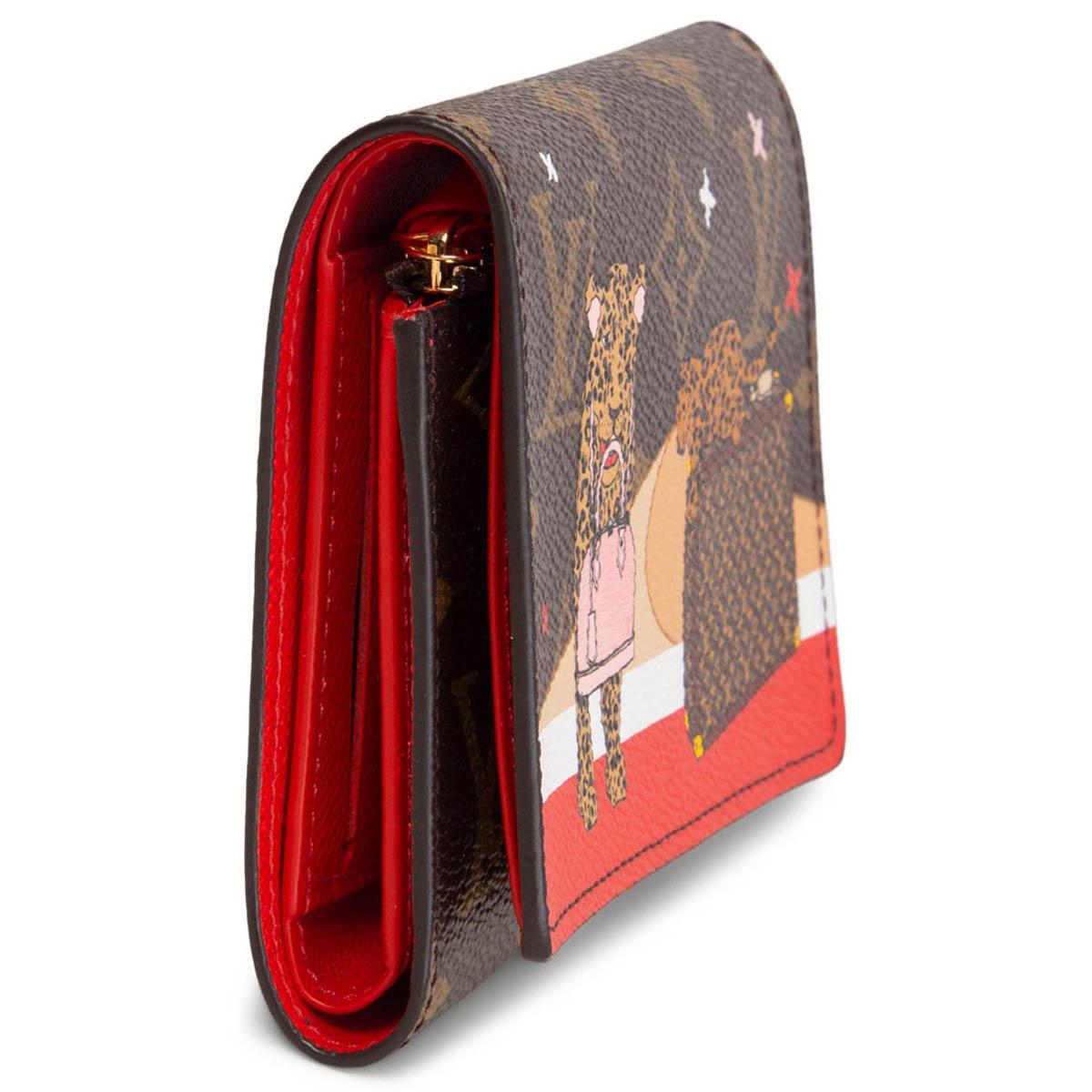 100% authentic Louis Vuitton limited edition 2018 Christmas Animation Victorine wallet in brown monogram canvas with big cats, trunk and Alma print. Closes with a snap button. Lined in red leather with a zipper pocket for coins, six credit card