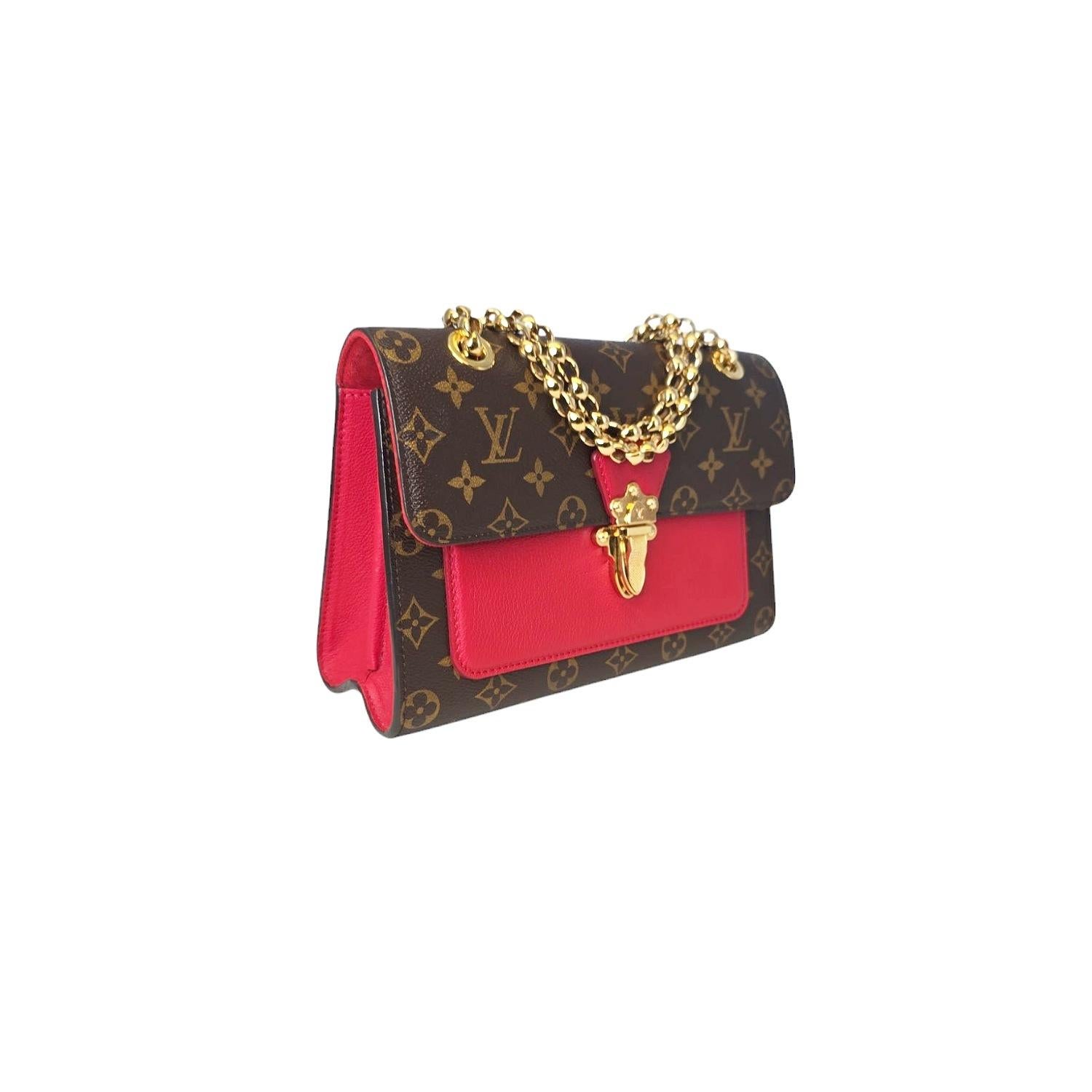 This Louis Vuitton Monogram Victoire is crafted of Louis Vuitton monogram coated canvas with cherry red side panels and front pocket. The bag features polished brass bijoux chain link shoulder straps and a facing brass press-lock for the flap. This