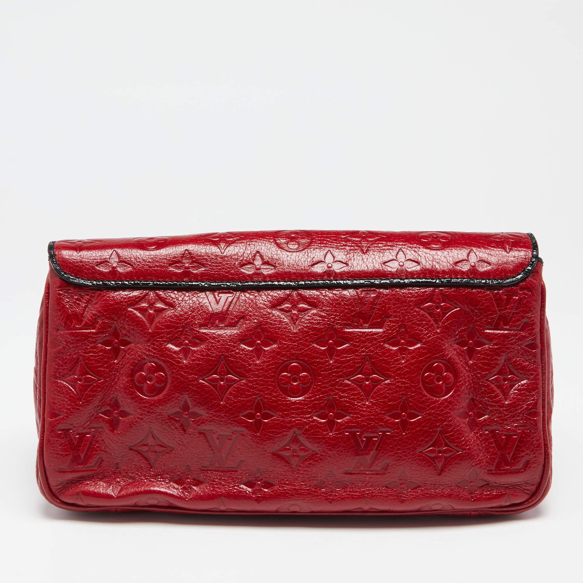 This My Deer Enigme clutch from Louis Vuitton is a stylish creation that is exceptionally well-made. Crafted from red Monogram glossy leather, this clutch is embellished beautifully with gold-toned hardware. It unveils a leather-satin interior,