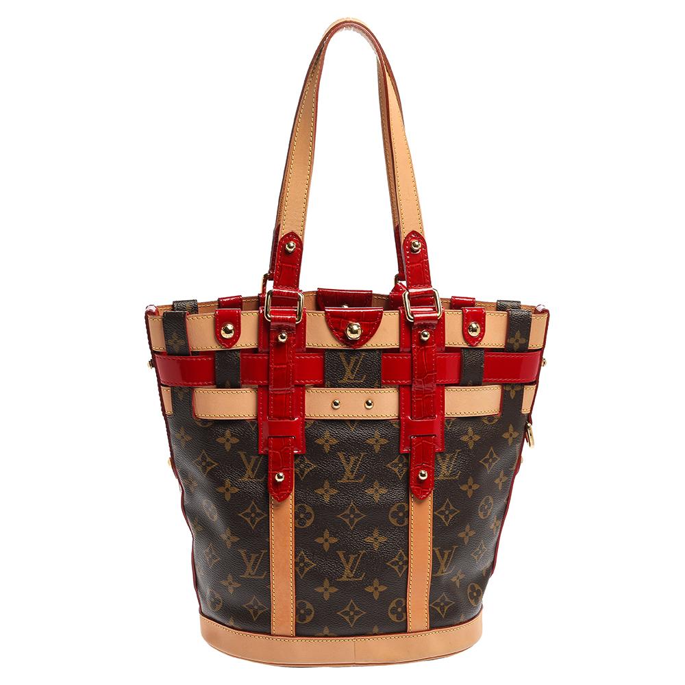 From the 2007 Collection, the Louis Vuitton Rubis Neo bag is crafted from monogram coated canvas with natural leather trims and red patent crocodile-embossed leather. It features an open-top that reveals a spacious interior that can house your