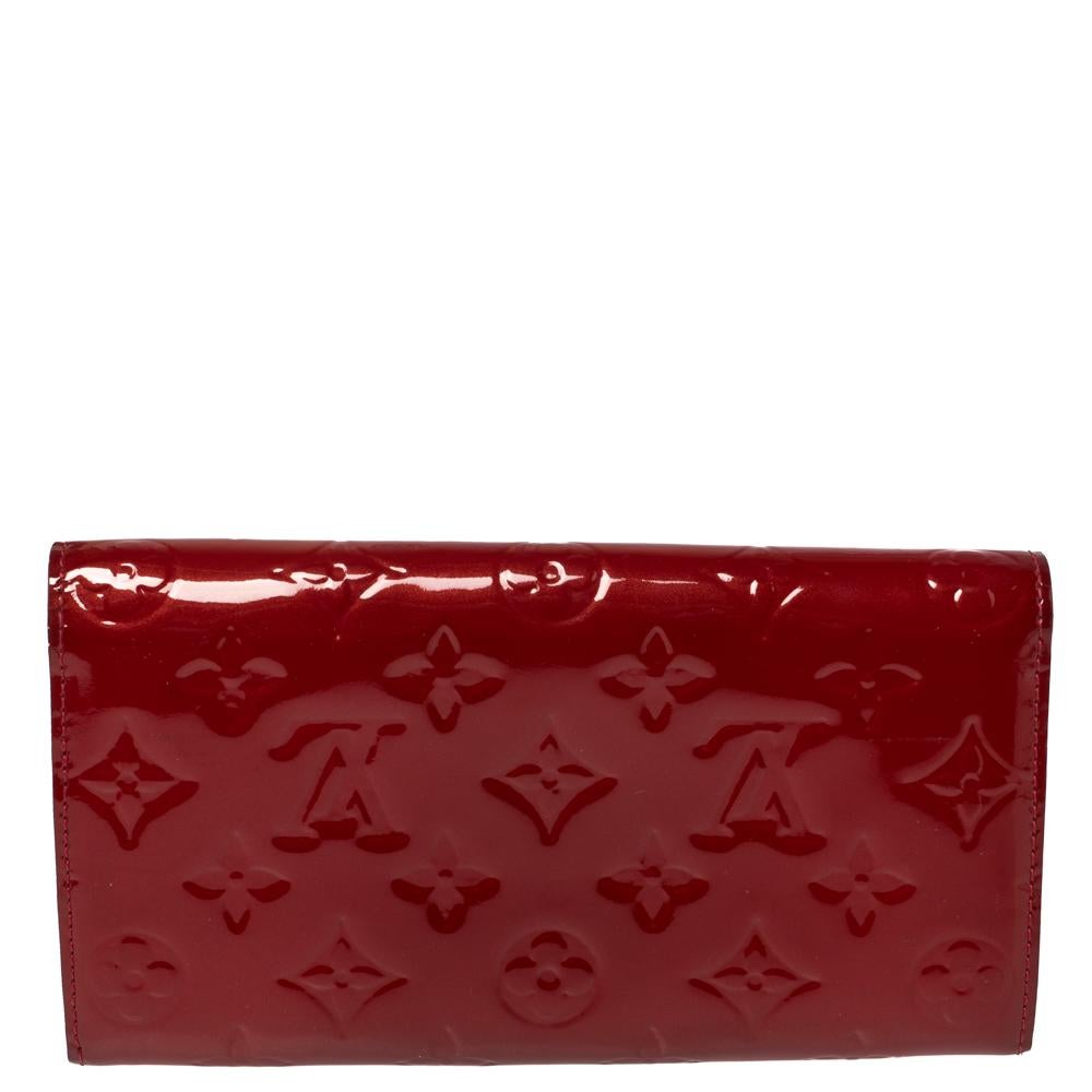 One of the most famous wallets by Louis Vuitton is the Sarah. This one here comes made from Monogram Vernis leather and the button on the flap opens to an interior with multiple card slots and a zip pocket. Perfect in size, this wallet can easily