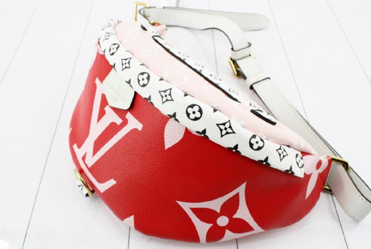 Red, pink, white and black monogram Giant and Mini monogram coated canvas Louis Vuitton Bumbag featuring gold-tone hardware, single cowhide leather waist strap with buckle adjustments, single flat top handle, pink canvas interior lining and dual zip