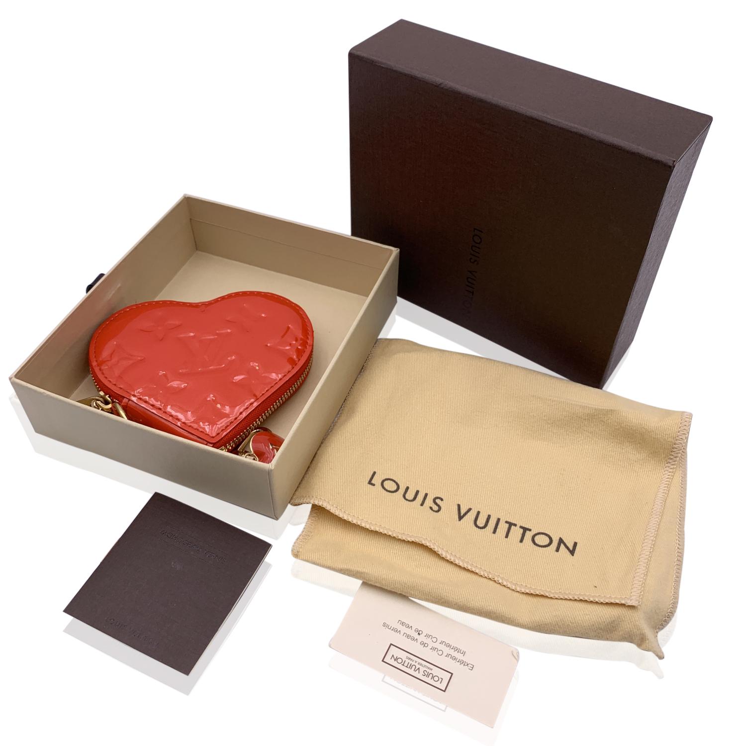 Louis Vuitton red Pomme d'Amour Monogram vernis leather Heart coin purse. Gold metal chain with heart shaped LV charm and a hook closure. Upper zipper closure. 'Louis Vuitton Paris - made in france' engraved on leather inside. Authenticity serial