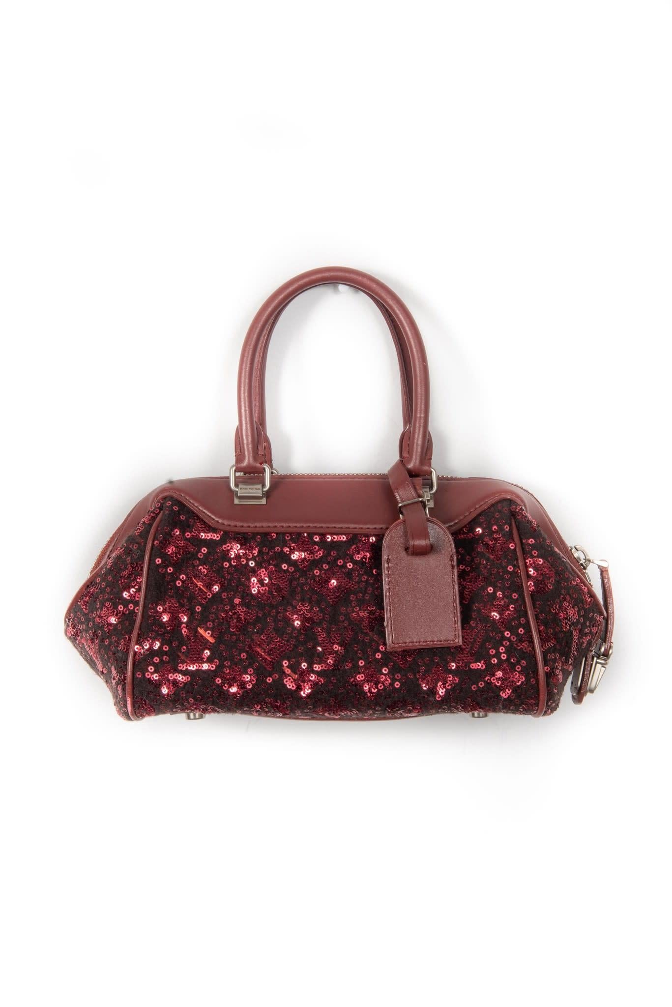 Made from wool with sequin-embroidery in the monogram pattern with dark red leather finishes. Limited edition bag features silver tone hardware, leather finishes, 2 rolled leather top handles, top zip closure and woven fabric interior lining. 