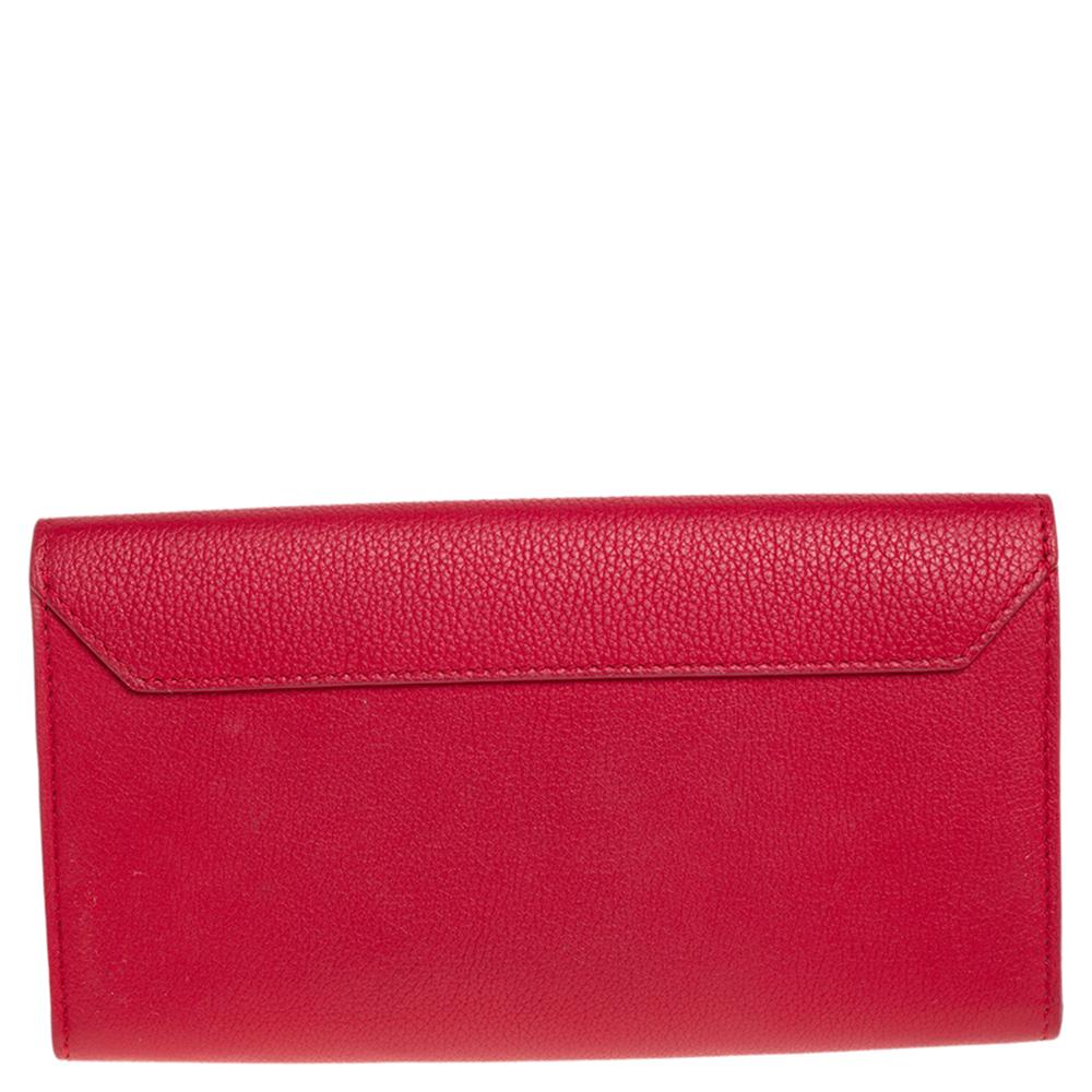 This gorgeous Lock Me ll wallet by Louis Vuitton will be a joy to carry around. Made from red leather, the flap features the signature LV logo in silver-tone metal. It opens to reveal a leather-fabric interior with multiple card slots and one zipped