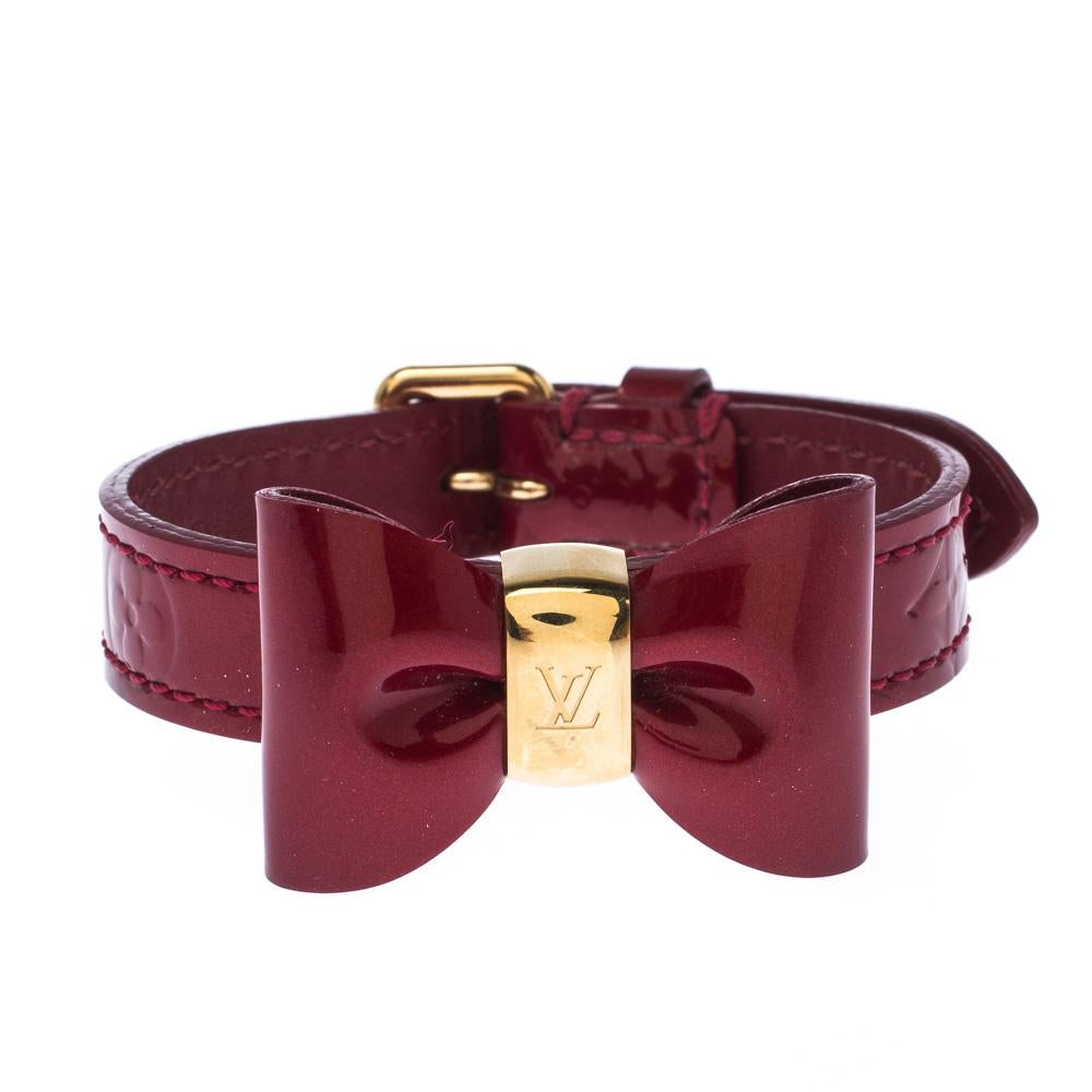 Add a touch of feminine style to your look with this Favorite bracelet from Louis Vuitton. This bracelet is made with red monogram Vernis leather and gold-tone hardware. It features a bow detail at the front and buckle closure. A classy piece that