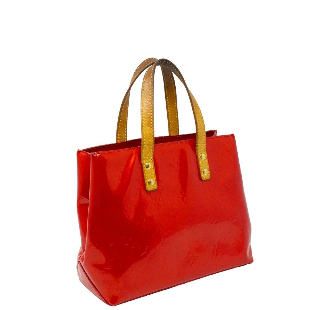 Super cute mini Louis Vuitton tote crafted in red patent vernis with the signature monogram print, dual vachetta leather handles—the open top opens up to a red tonal canvas interior with a single zippered pocket. This mini tote is perfect for