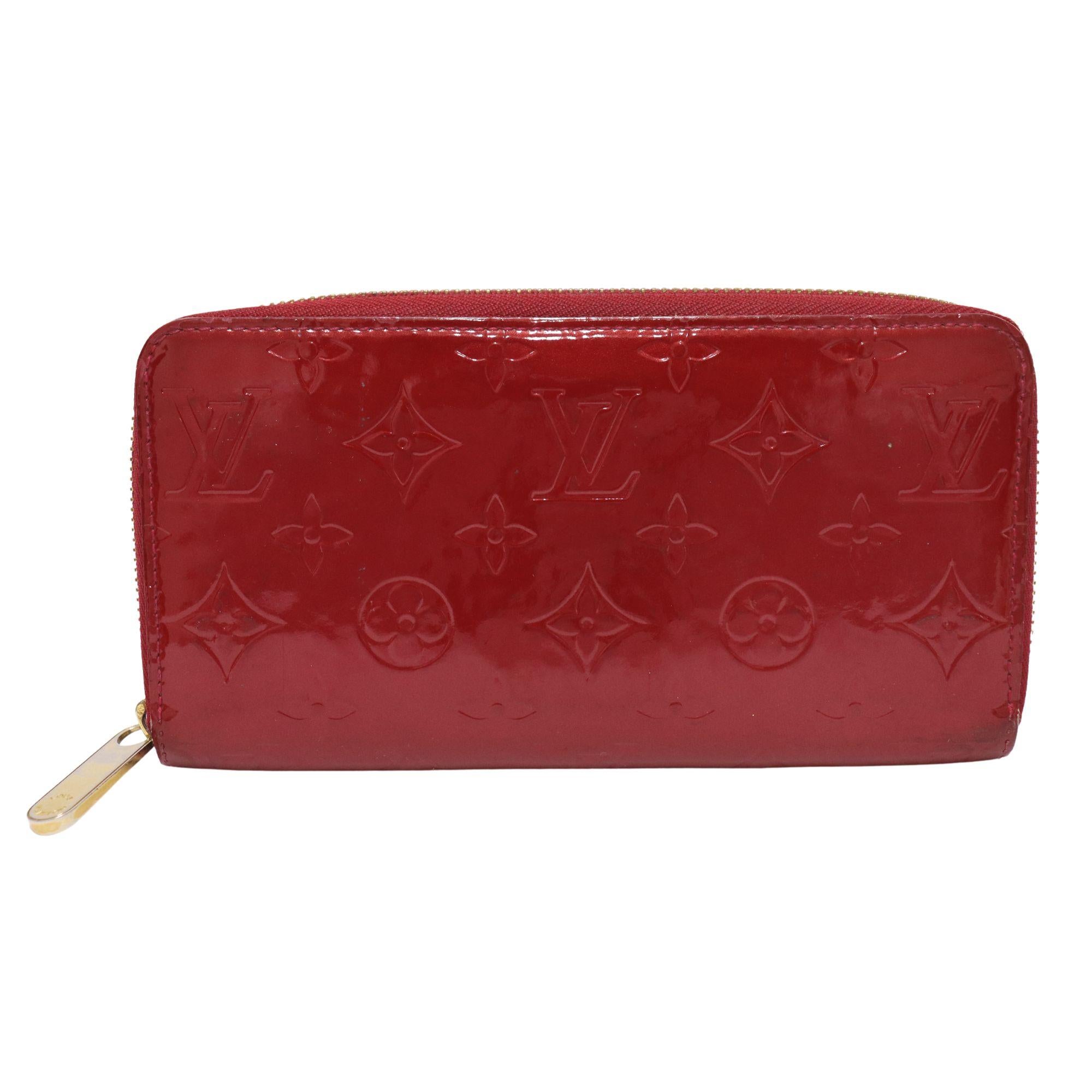 Louis Vuitton red vernis zippy wallet. Features gold tone hardware. Full zip around opens to red leather interior with 8 card slots. Middle zipped coin compartment, and multiple bill pockets.

Measurements:
Height: 10cm
Width: 19cm
Depth: