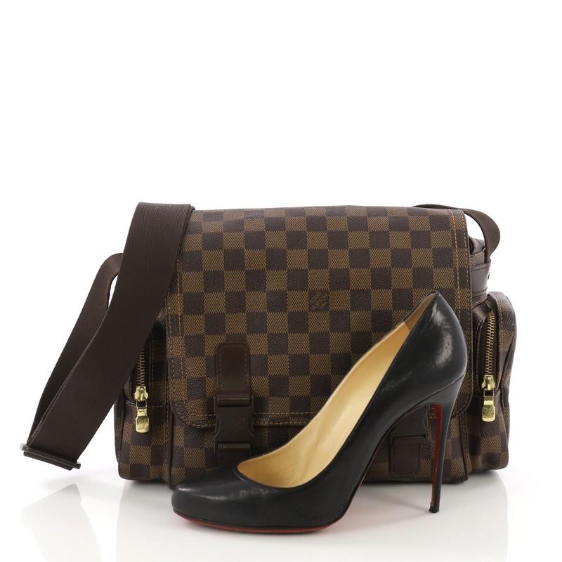 This Louis Vuitton Reporter Melville Bag Damier, crafted in damier ebene coated canvas, features an adjustable dark brown textile strap, exterior side zip pockets, and gold-tone hardware. Its push-lock closure opens to a brown fabric interior with