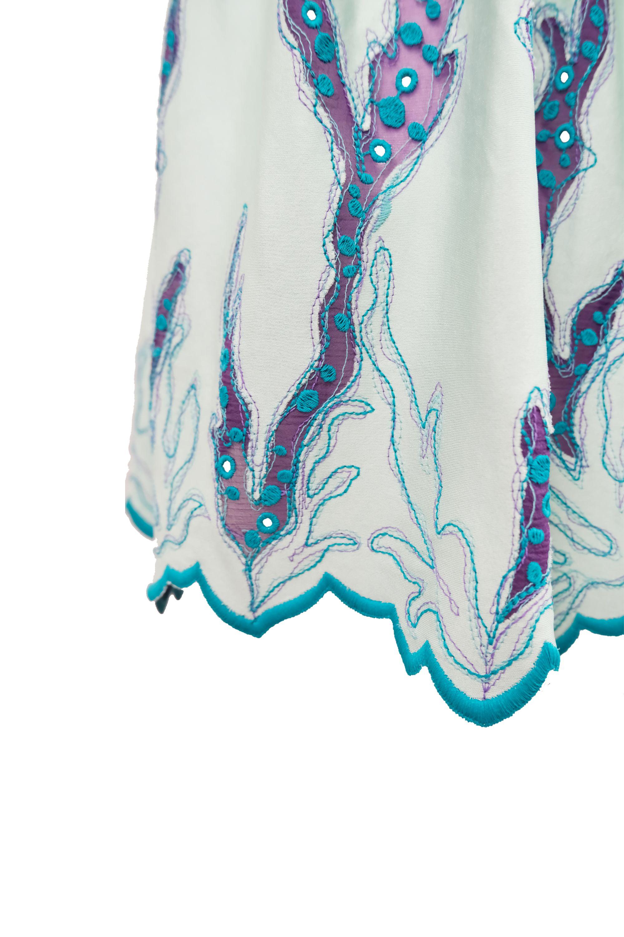 Este minivestido Louis Vuitton, que cierra la colección Resort 2015, luce un llamativo estampado de inspiración coral, bordado intrincadamente con gasa púrpura transparente. El bordado en tonos vibrantes de verde azulado y azul contrasta de