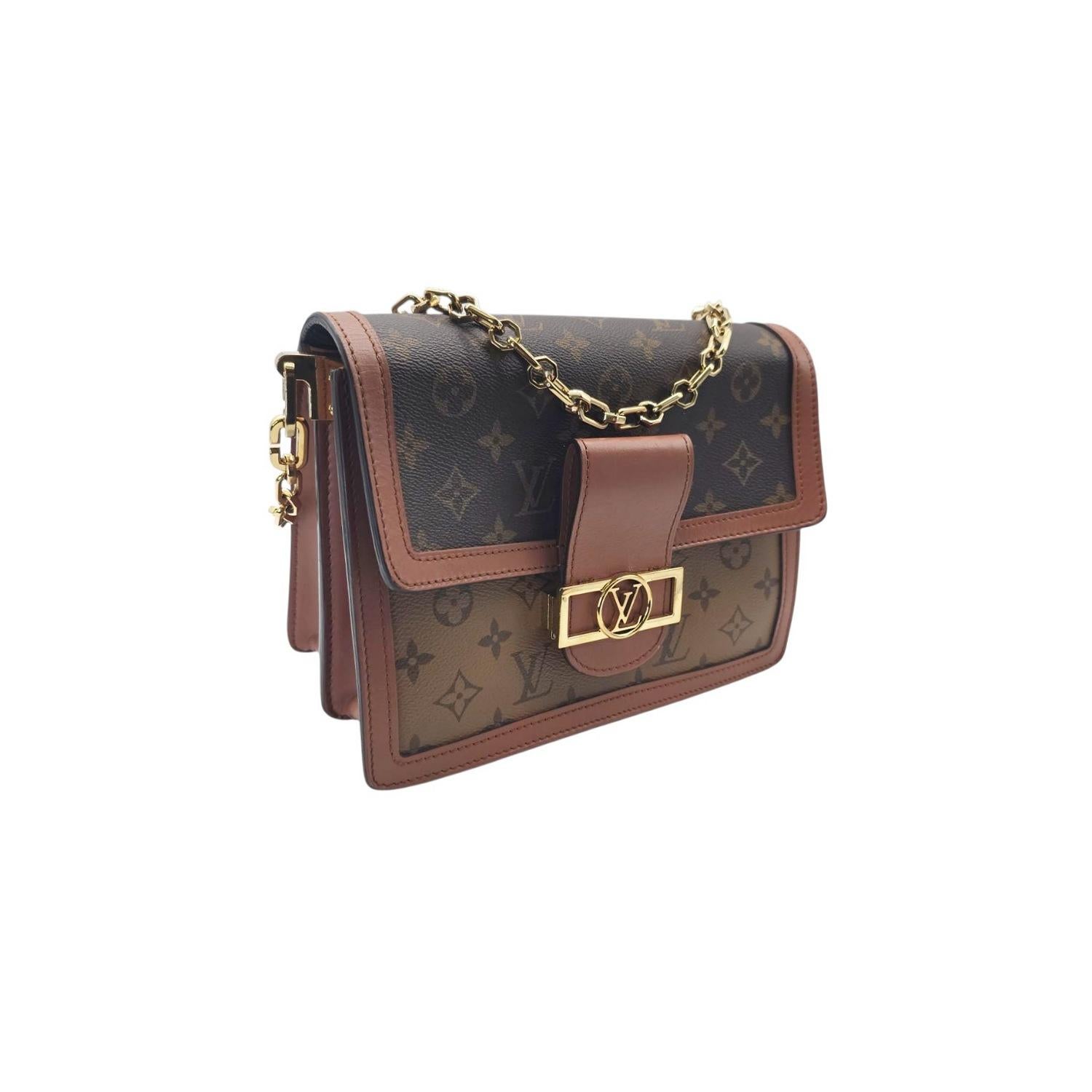 This Louis Vuitton Reverse Monogram Dauphine MM is crafted of Louis Vuitton monogram on toile canvas. The bag features a toffee-colored leather shoulder strap, a gold chain strap, and a facing flap with a toffee leather trim and a decorative brass