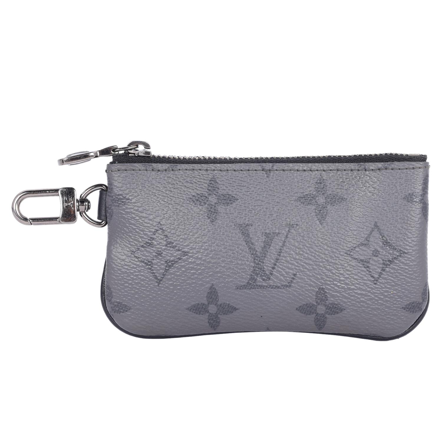 Authentic, pre-loved Louis Vuitton reverse monogram Eclipse trio messenger key pouch. Features Louis Vuitton monogram toile canvas that is reversible in color, zipper top closure, d-ring clasp to attach to your handbags. The interior is black and is