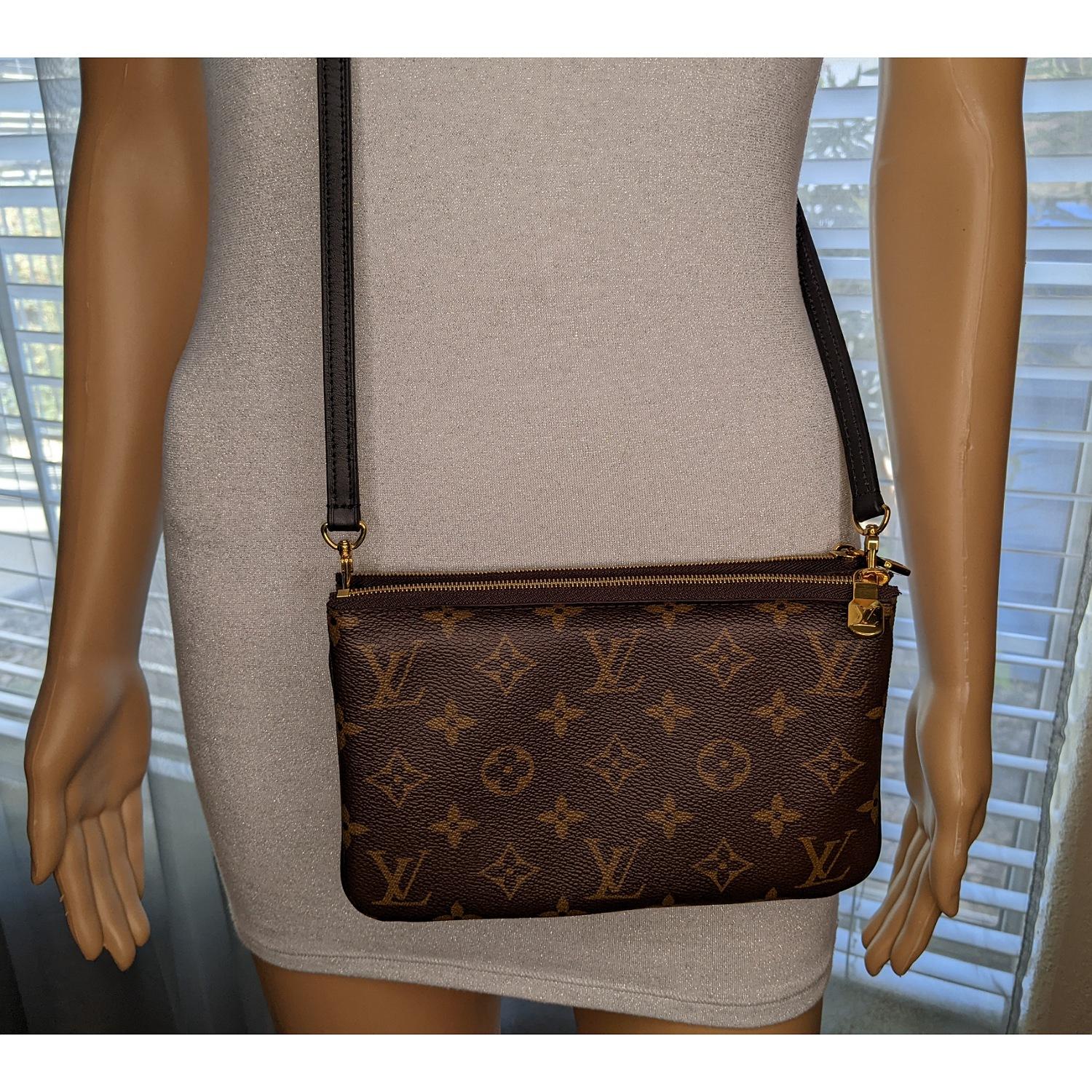 This stylish pochette is crafted of traditional Louis Vuitton monogram on toile canvas with a giant reverse monogram canvas on the opposite side. This shoulder bag features black leather trim, a black adjustable leather shoulder strap, and two top
