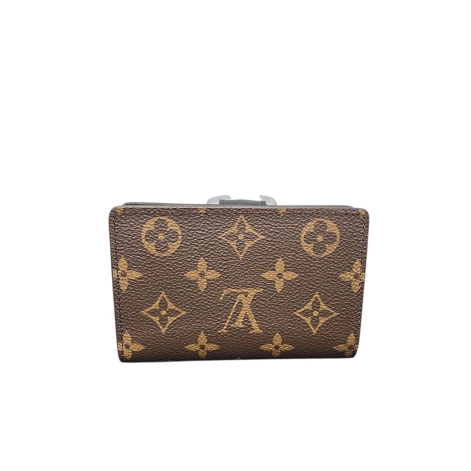 This Louis Vuitton Reverse Monogram Juliette Wallet is crafted of Louis Vuitton monogram on toile canvas. The wallet features a polished gold LV logo snap closure on the facing flap that opens to a black cross-grain leather interior with card slots,