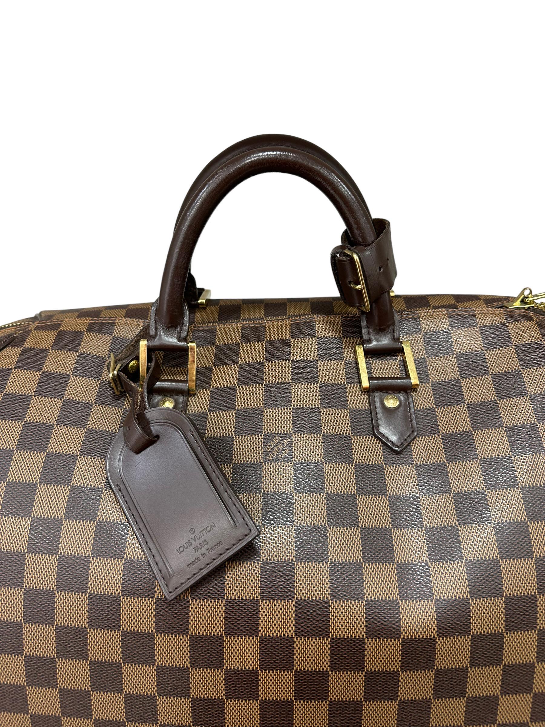 Louis Vuitton travel bag, Ribera model, size GM, made of brown canvas in the Damier ebene pattern, with brown leather trim and gold hardware. Equipped with a top zip closure, complete with padlock, keys and leather address holder. Fitted with a