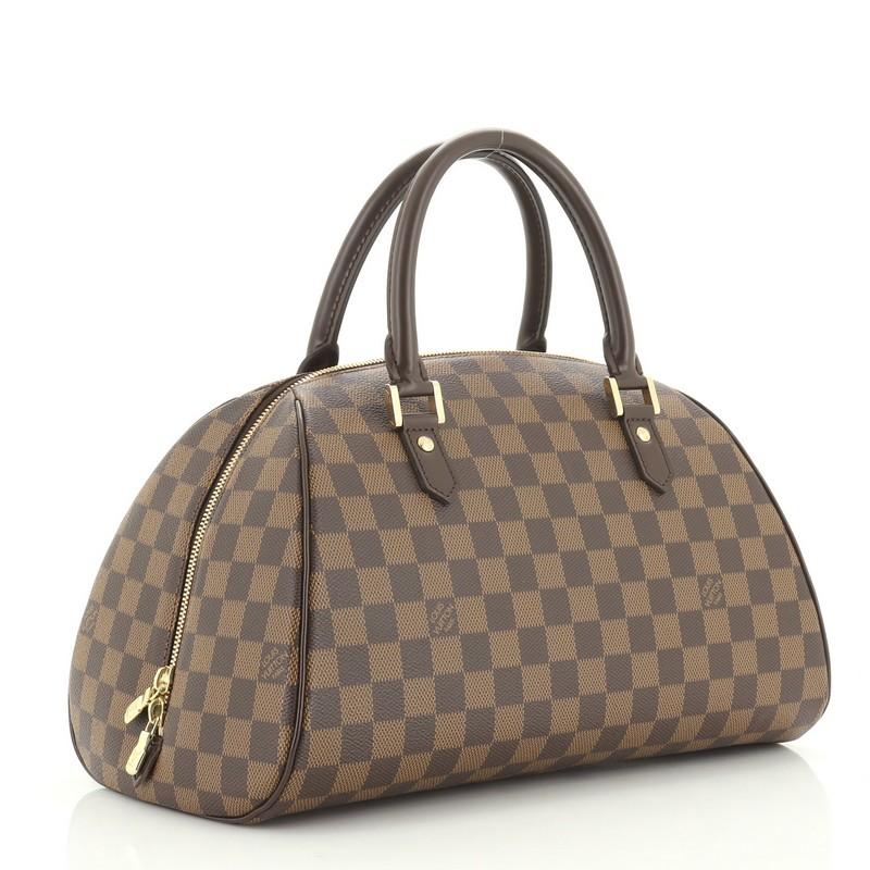 This Louis Vuitton Ribera Handbag Damier MM, crafted from damier ebene coated canvas, features dual rolled leather handles, leather trim, and gold-tone hardware. Its two-way zip closure opens to an orange fabric interior with slip pockets.