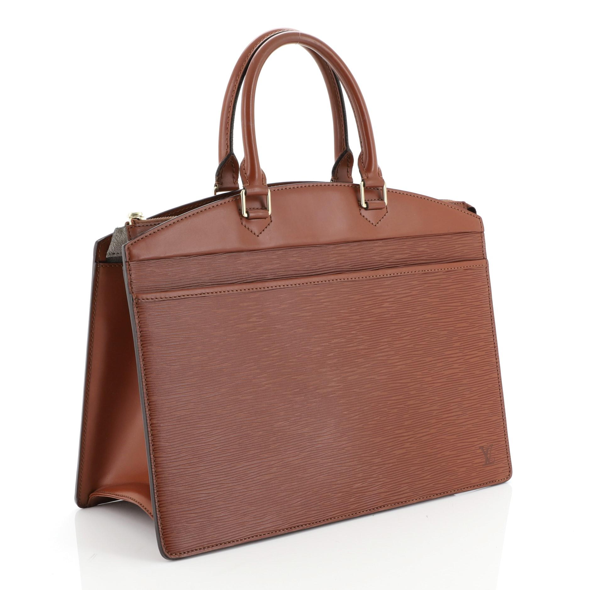 This Louis Vuitton Riviera Handbag Epi Leather, crafted from brown epi leather, features dual rolled leather handles, full-length exterior front pocket, subtle LV monogram side logo, and gold-tone hardware. Its top zip closure opens to a brown