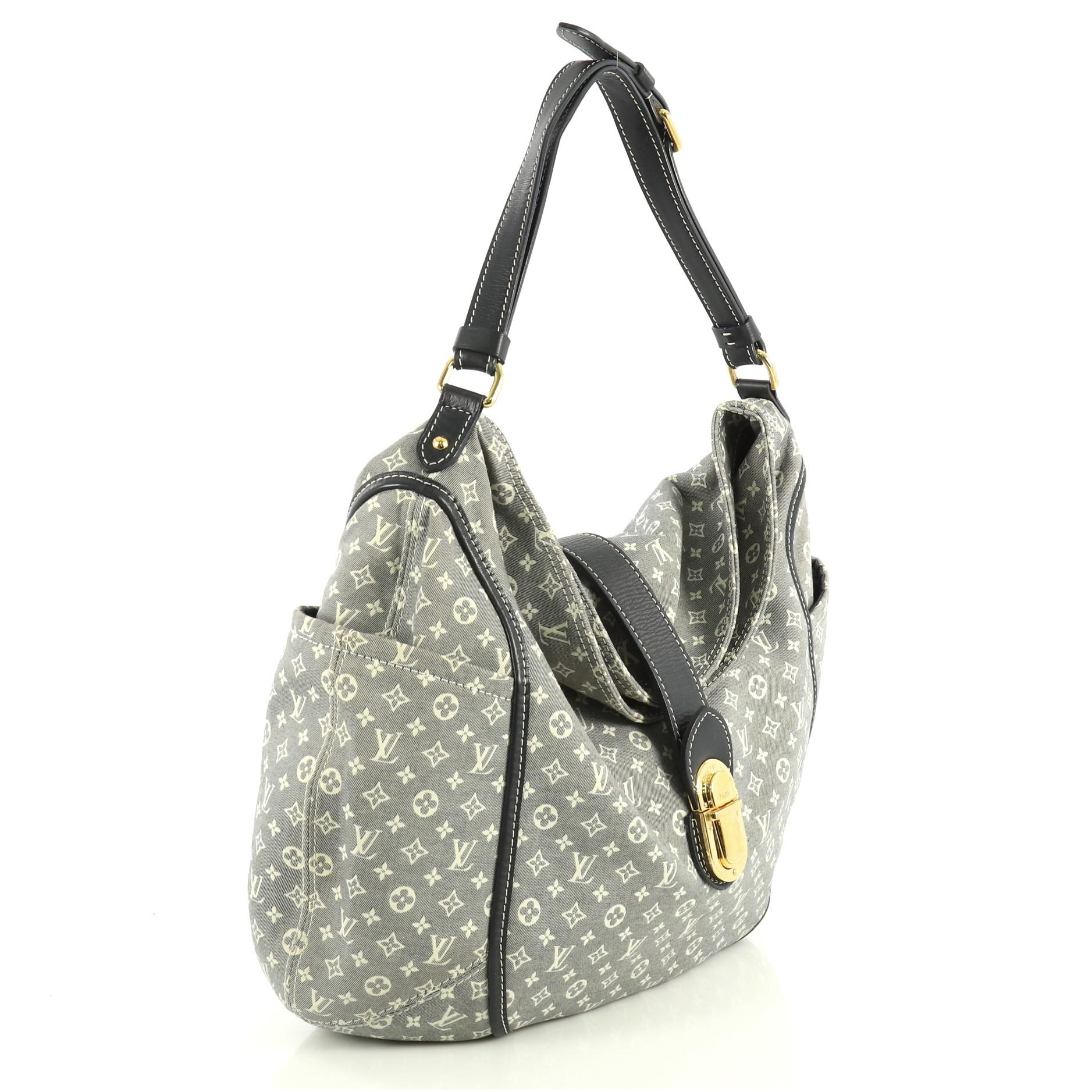 This Louis Vuitton Romance Handbag Monogram Idylle, crafted with blue monogram idylle, features exterior side slip pockets, adjustable shoulder strap, and gold-tone hardware. Its snap closure opens to a blue fabric interior with slip pockets.