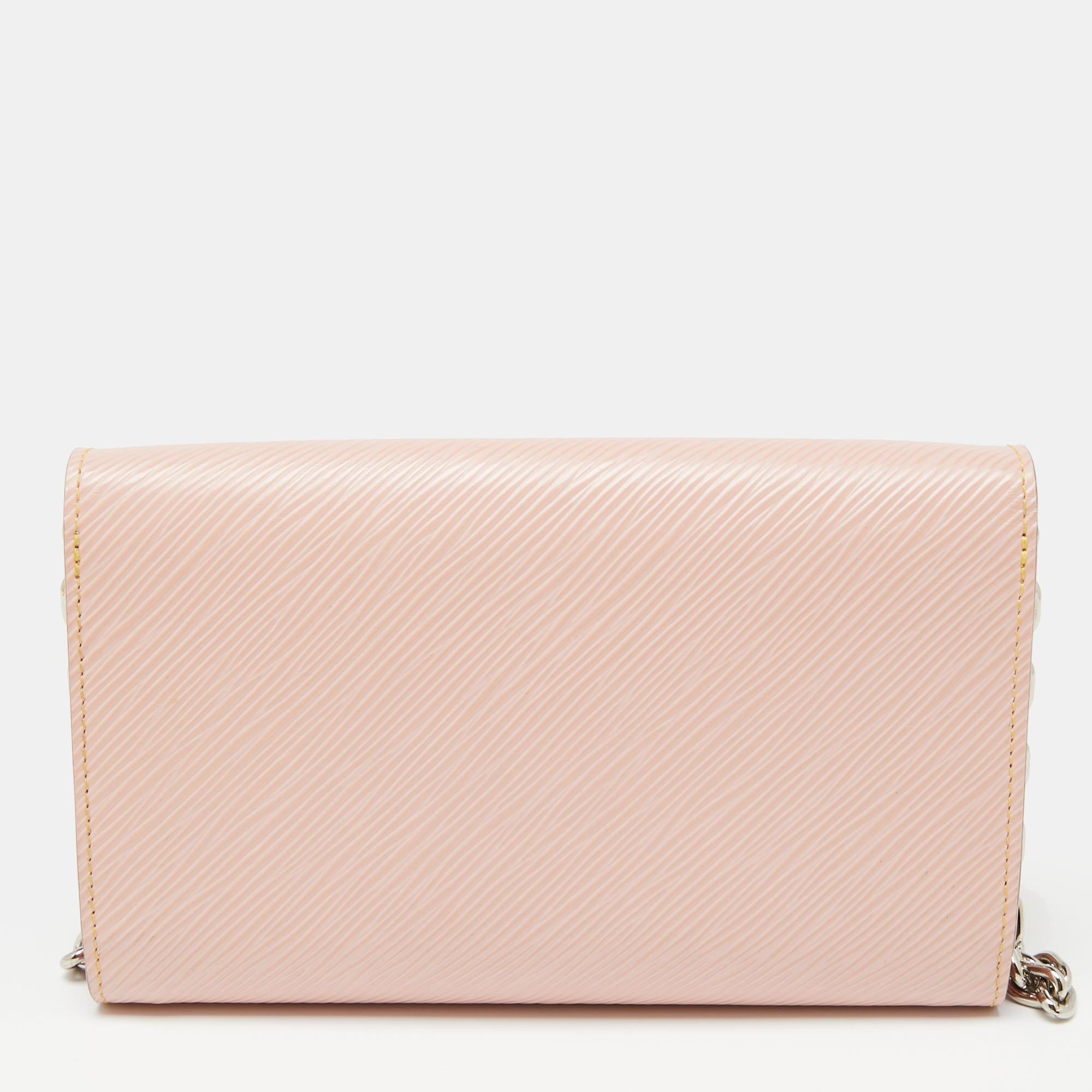 A creative innovation, this Louis Vuitton WOC is elegant and captivating. Crafted from rose ballerina Epi leather, this bag features a structured design with a single chain shoulder strap and its exterior is decorated with beautiful flower