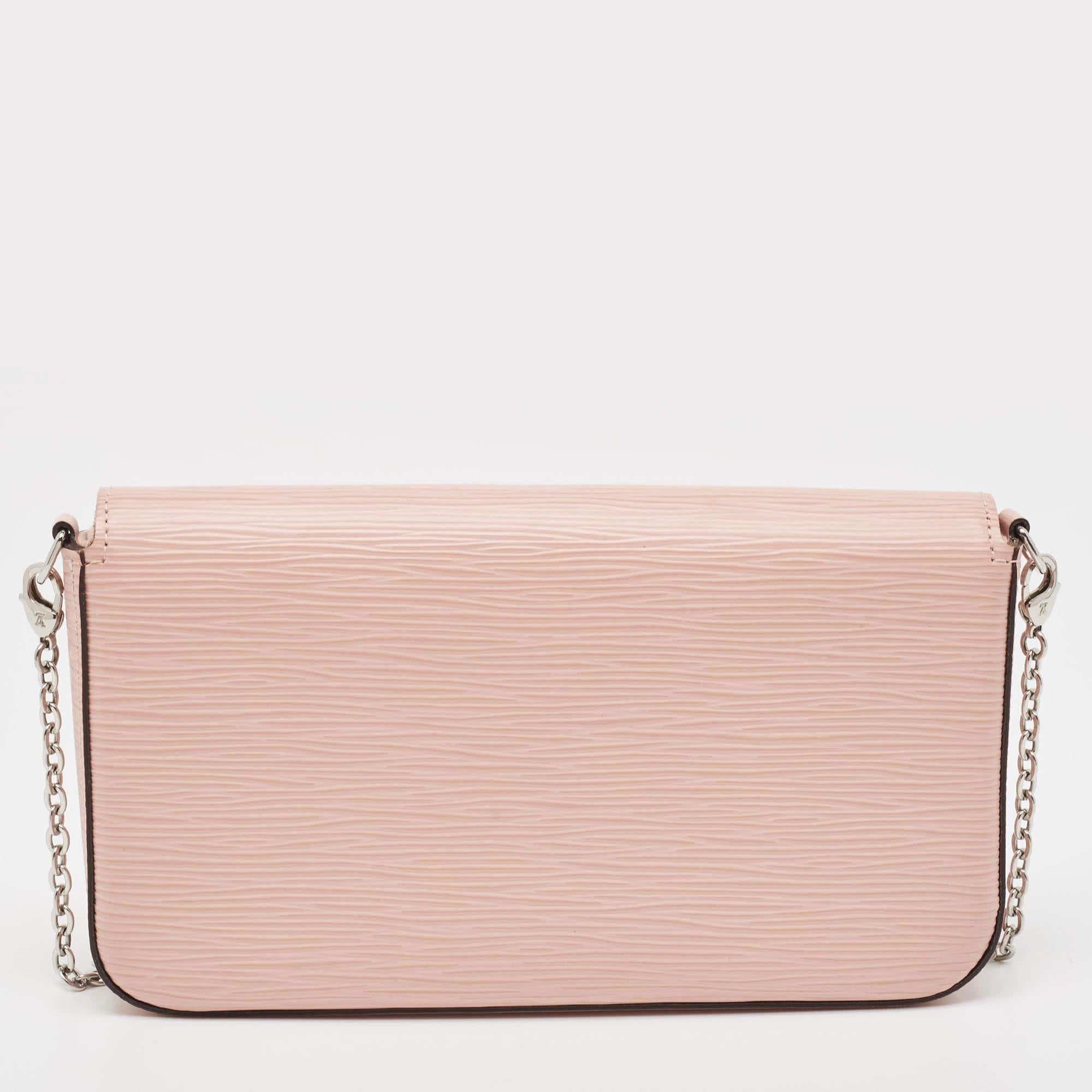 This Pochette Félicie has been designed to be a shoulder bag as well as a clutch. It is crafted from Rose Ballerine Epi leather and has an Alcantara-lined interior, an envelope flap, and a silver-tone chain. The bag comes in a convenient size that