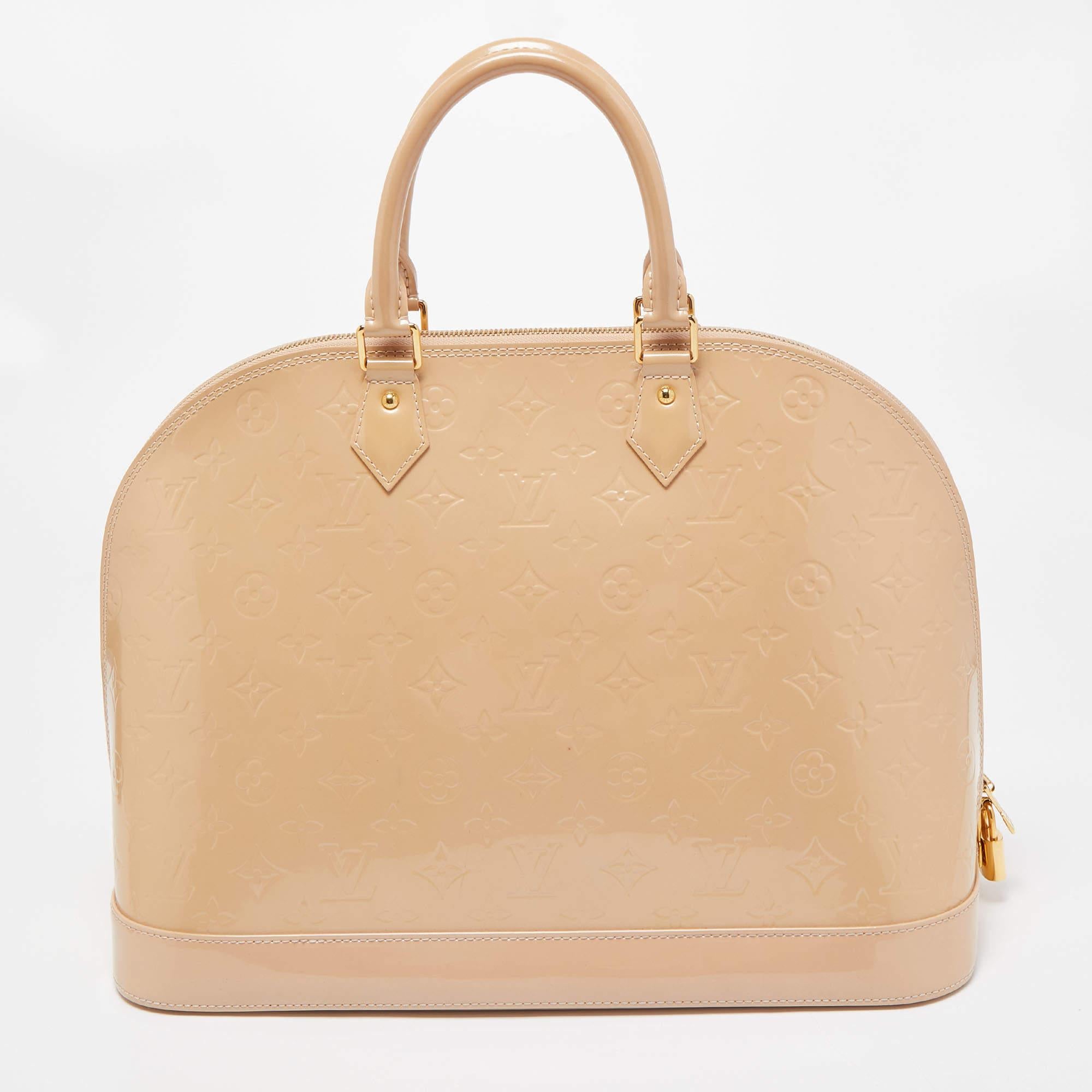 From one of the most iconic collections of Louis Vuitton, this Alma GM bag is imbued with exquisite craftsmanship and historic details. Constructed from Rose Monogram Vernis, it displays dual top handles, gold-tone hardware, and a padlock. The