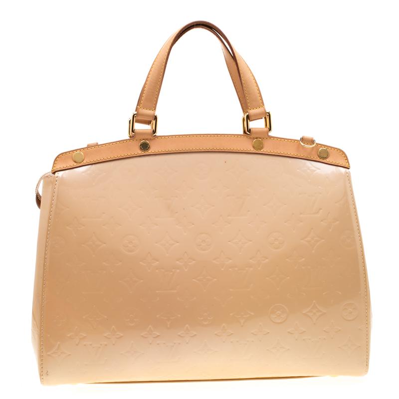 Louis Vuitton Brea's feminine shape is inspired by the doctor's bag. Crafted from signature patent leather, the bag has a perfect finish. The fabric lined interior is spacious and it is secured by a zipper. The bag features double handles,