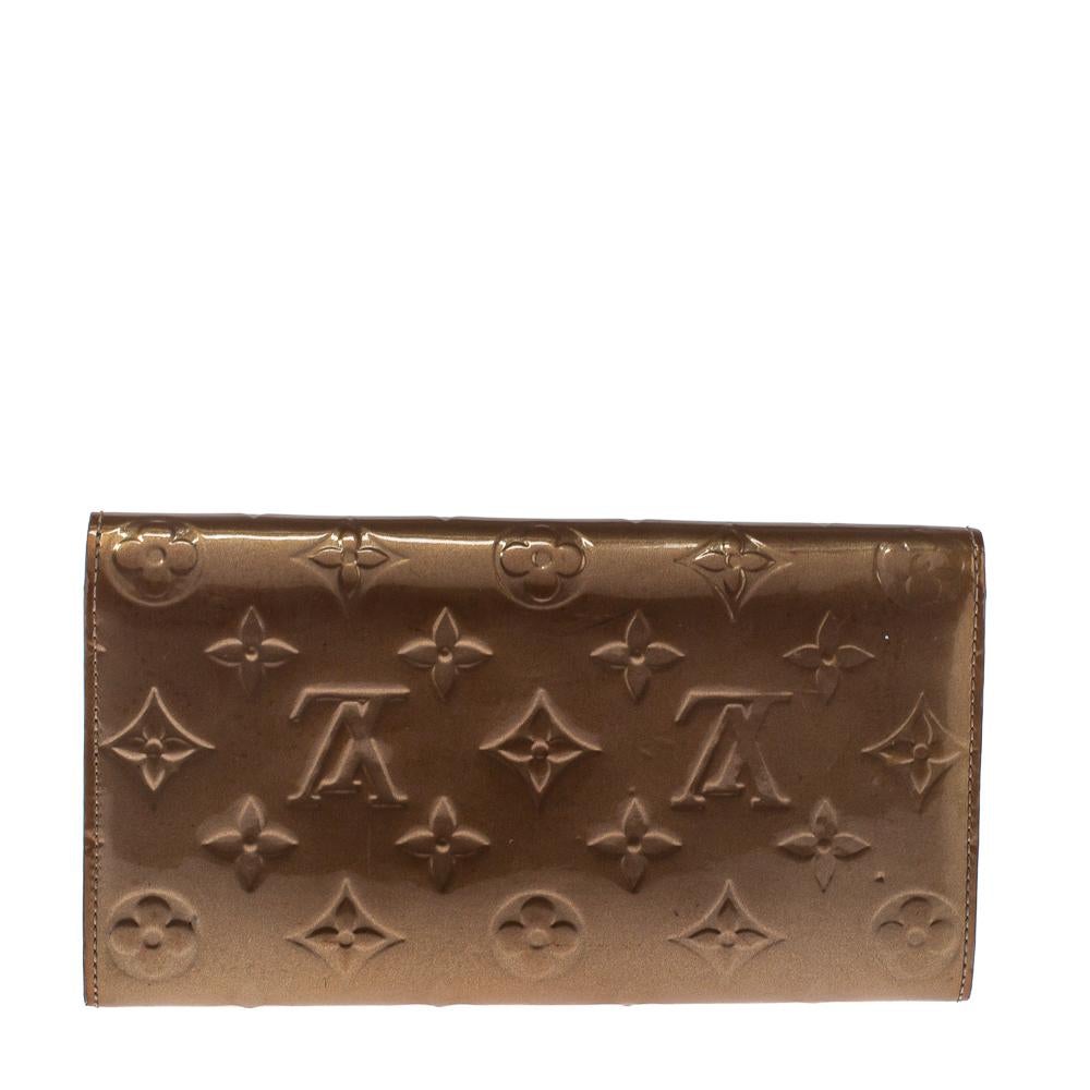 One of the most famous wallets by Louis Vuitton is the Sarah. This one here comes made from Monogram Vernis leather and the button on the flap opens to an interior with multiple card slots and a zip pocket. Perfect in size, this wallet can easily