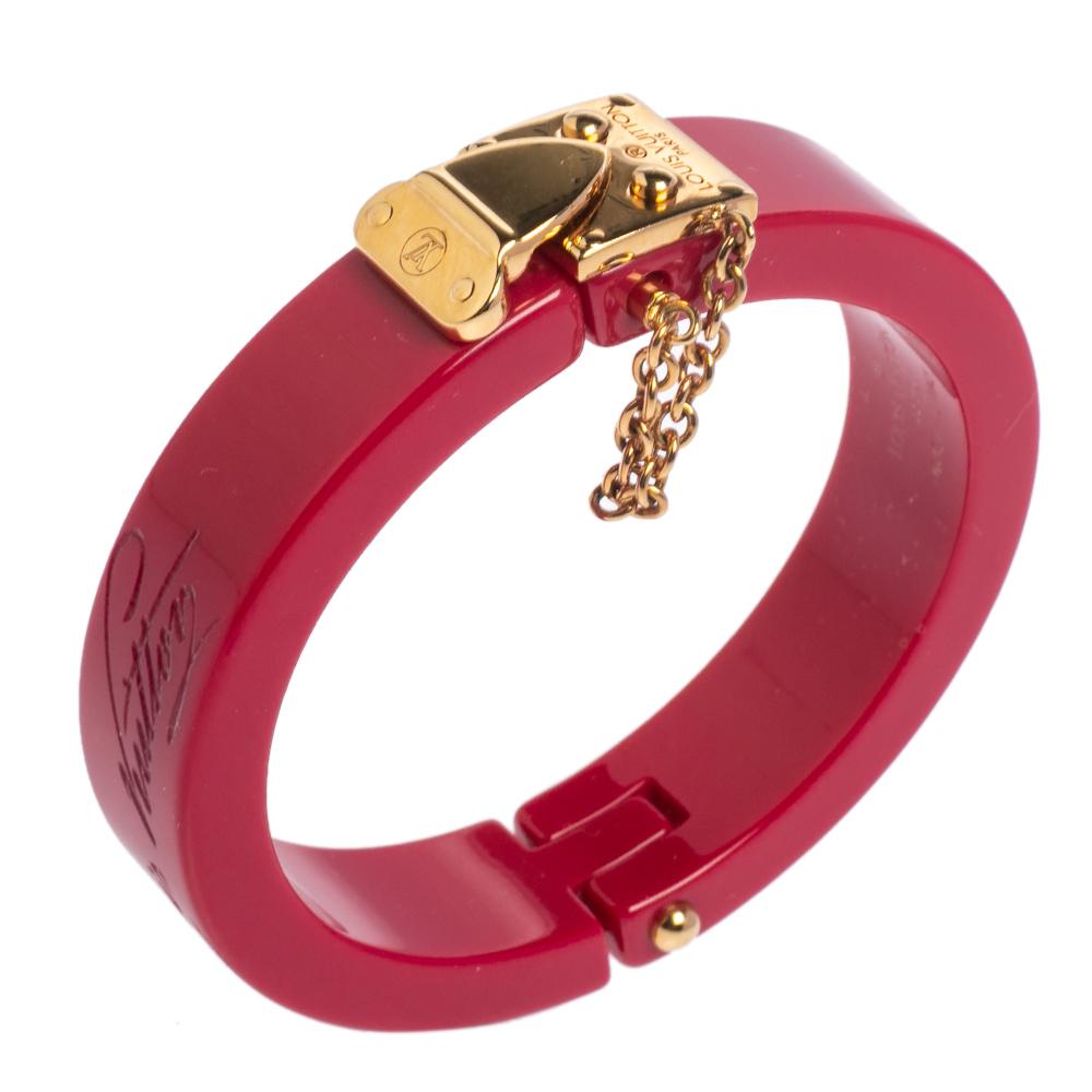 This Lock Me bracelet from Louis Vuitton, exuding a bold finish, will be your new favorite statement accessory. Constructed with resin and gold-tone metal, it features a thick chain accent to the side and a slide lock clasp. It has a sturdy built