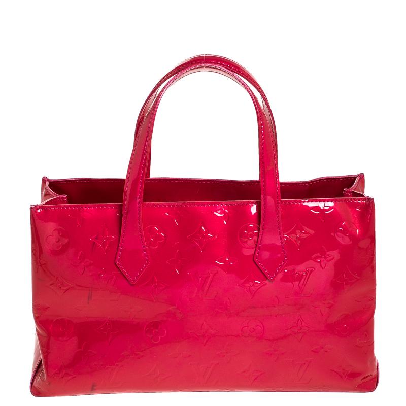 Louis Vuitton's handbags are popular owing to their high style and functionality. This Wilshire bag, like all the other handbags, is durable and stylish. Crafted from patent leather, the red bag comes with dual handles and a top with a hook that