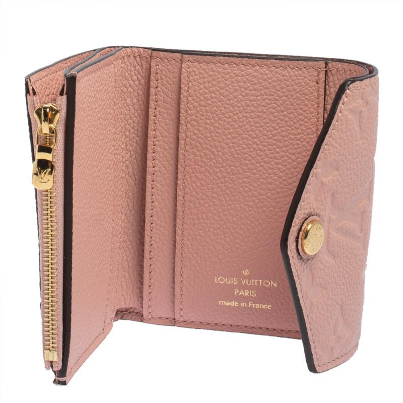 This Zoe wallet by Louis Vuitton helps you keep your essentials organized and secured in style. Crafted from signature monogram Empreinte leather, it features a flap closure that reveals an interior housing card slots and a zip pocket. It is