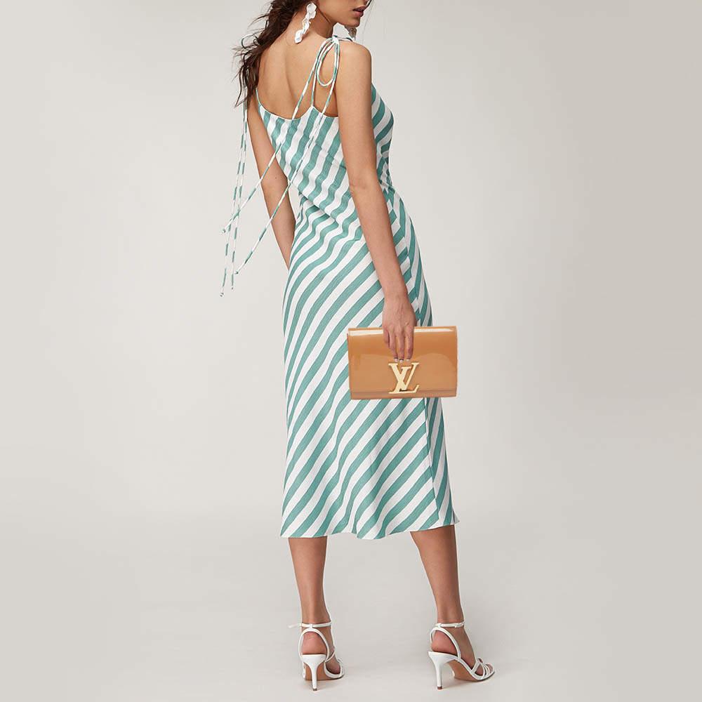 Idéale pour ranger vos objets de valeur sans alourdir votre look, cette pochette LV se compose d'un extérieur en cuir verni et d'accessoires en métal doré. Portez-le à la main comme un accessoire de soirée élégant.