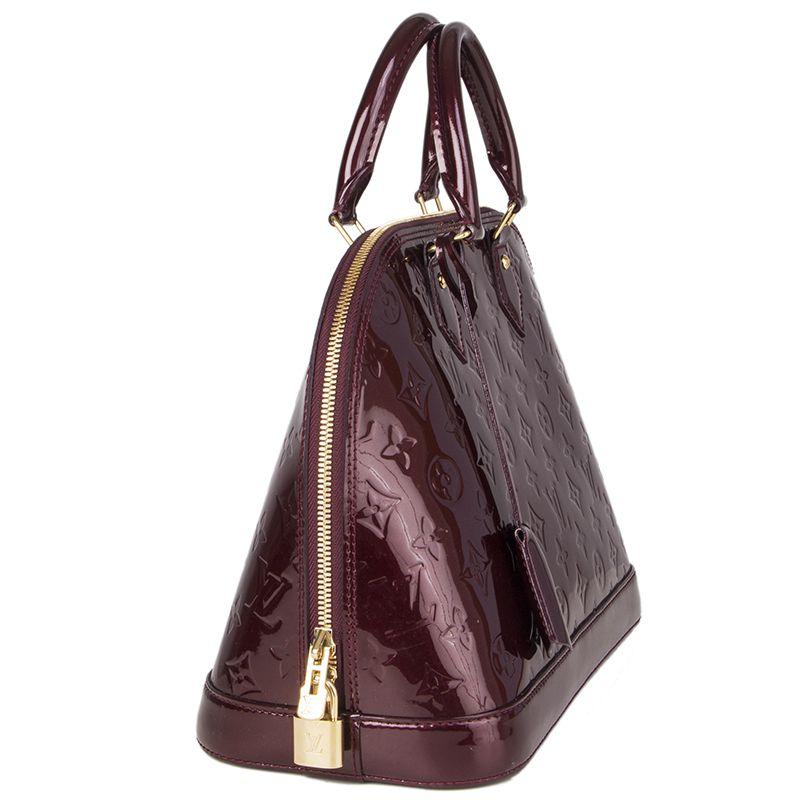 Louis Vuitton 'Alama PM' in Rouge Fauviste Monogram Vernis patent leather. Closes with a double zipp on top. Lined in canvas with two open pockets against the back. Has been carried and is in excellent condition. Comes with keys and lock.

Height