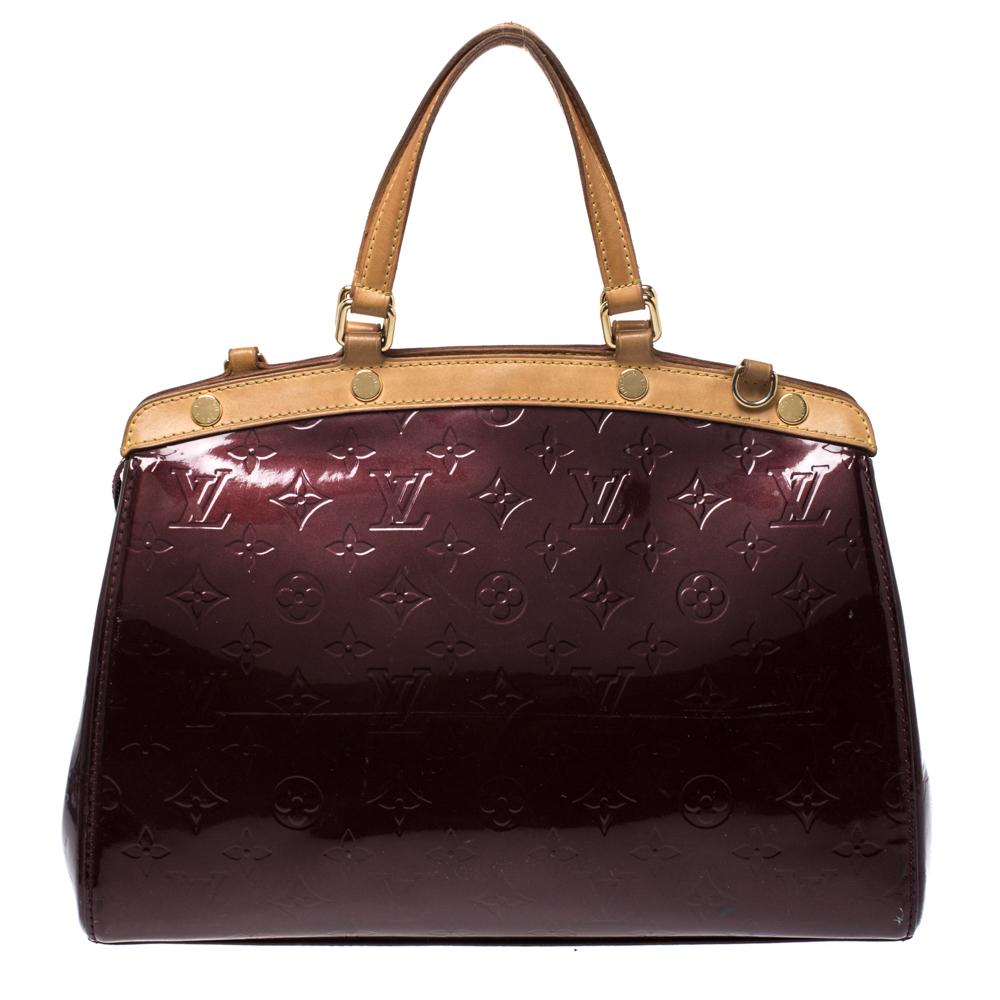 The feminine shape of Louis Vuitton's Brea is inspired by the doctor's bag. Crafted from Monogram Vernis in burgundy, the bag has a perfect finish. The fabric interior is spacious and it is secured by a zipper. The bag features double handles,