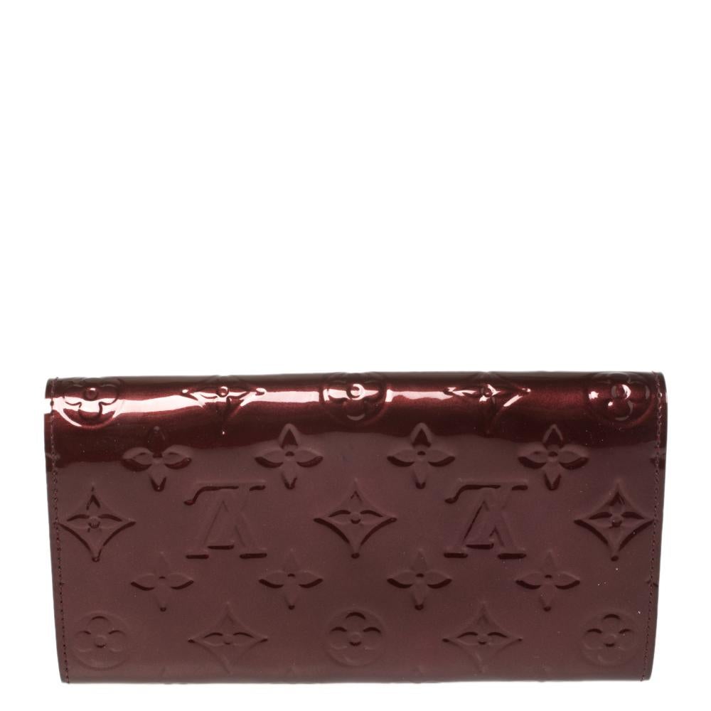 One of the most famous wallets by Louis Vuitton is the Sarah. This one here comes made from Monogram Vernis leather and the button on the flap opens to an interior with multiple card slots and a zip pocket. Perfect in size, this wallet can easily