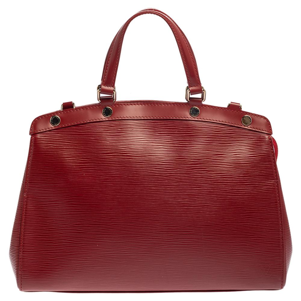 The feminine shape of Louis Vuitton's Brea is inspired by the doctor's bag. Crafted from Epi leather, the bag has a perfect finish. The fabric interior is spacious and it is secured by a zipper. The bag features double handles, protective metal feet