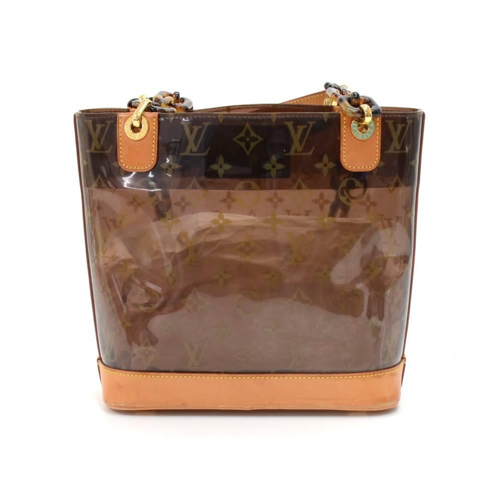 Louis Vuitton Sac Ambre PM in monogram vinyl and brown leather pieces from the Louis Vuittons Cruise Collection. It features a structure of clear Vinyl enforced with leather trimming and bottom. Can be carried in hand or shoulder with tortoise shell