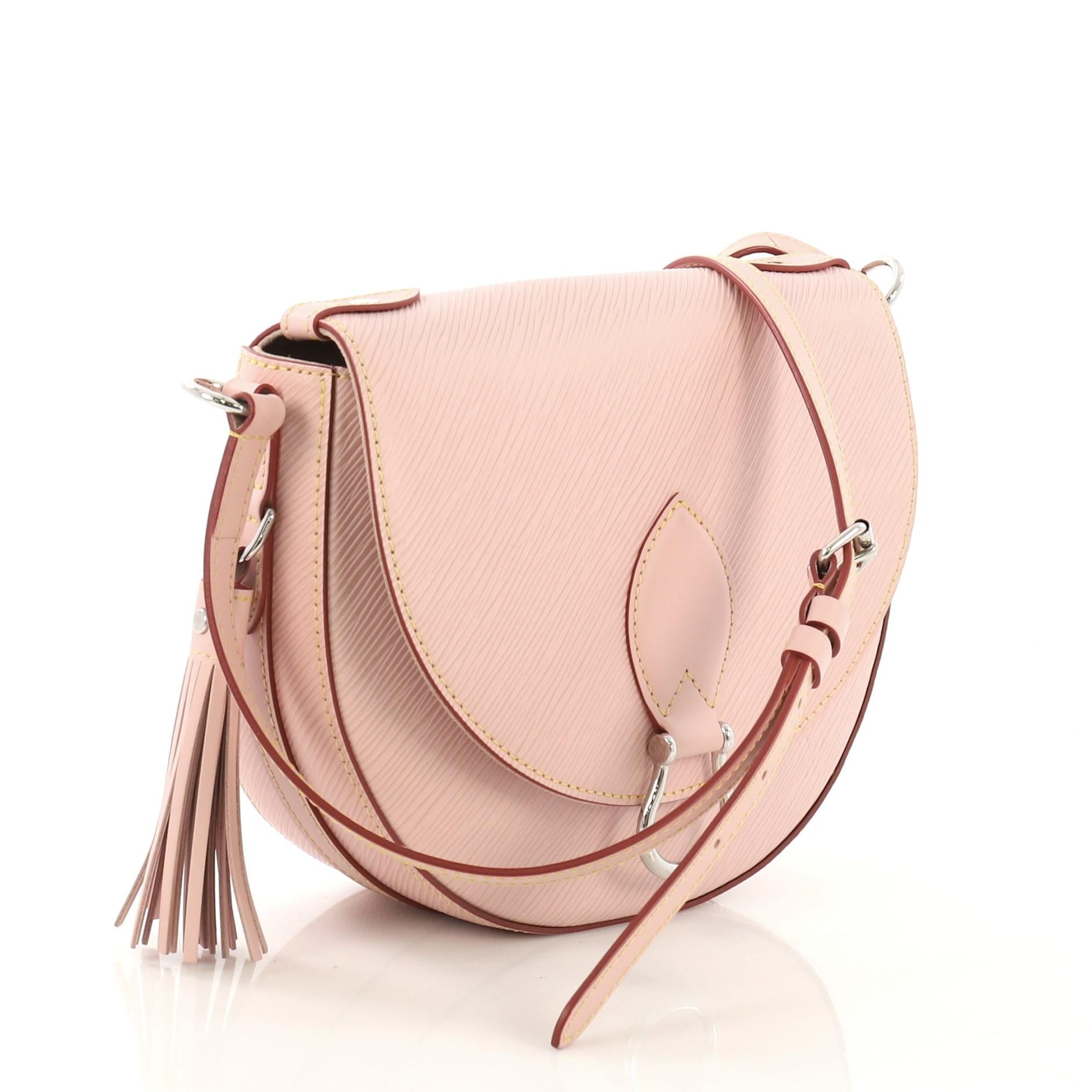 This Louis Vuitton Saint Cloud NM Bag Epi Leather, crafted in pink epi leather, features a long adjustable cross-body strap, front flap with metallic buckle, leather tassel, and silver-tone hardware. Its snap closure opens to a pink microfiber