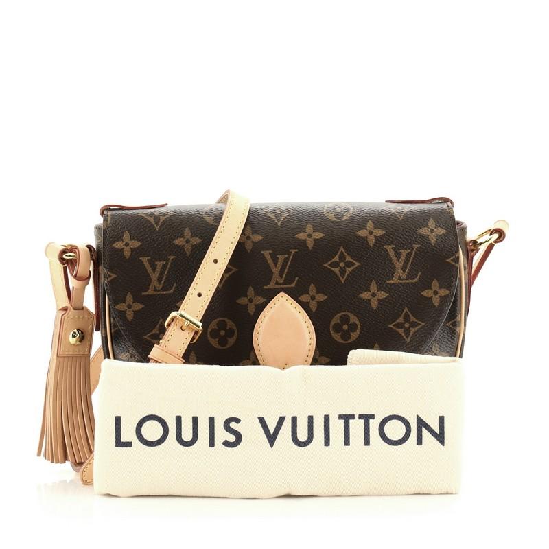 This Louis Vuitton Saint Cloud NM Bag Monogram Canvas, crafted in brown monogram coated canvas, features an adjustable cross-body strap, vachetta leather trim, front flap with buckle, leather tassel, and gold-tone hardware. Its snap button closure